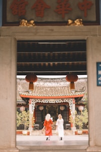 Two women enter a traditional chinese temple.