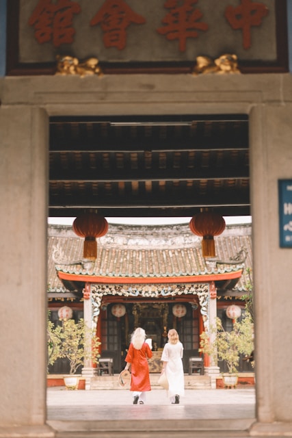Two women enter a traditional chinese temple.
