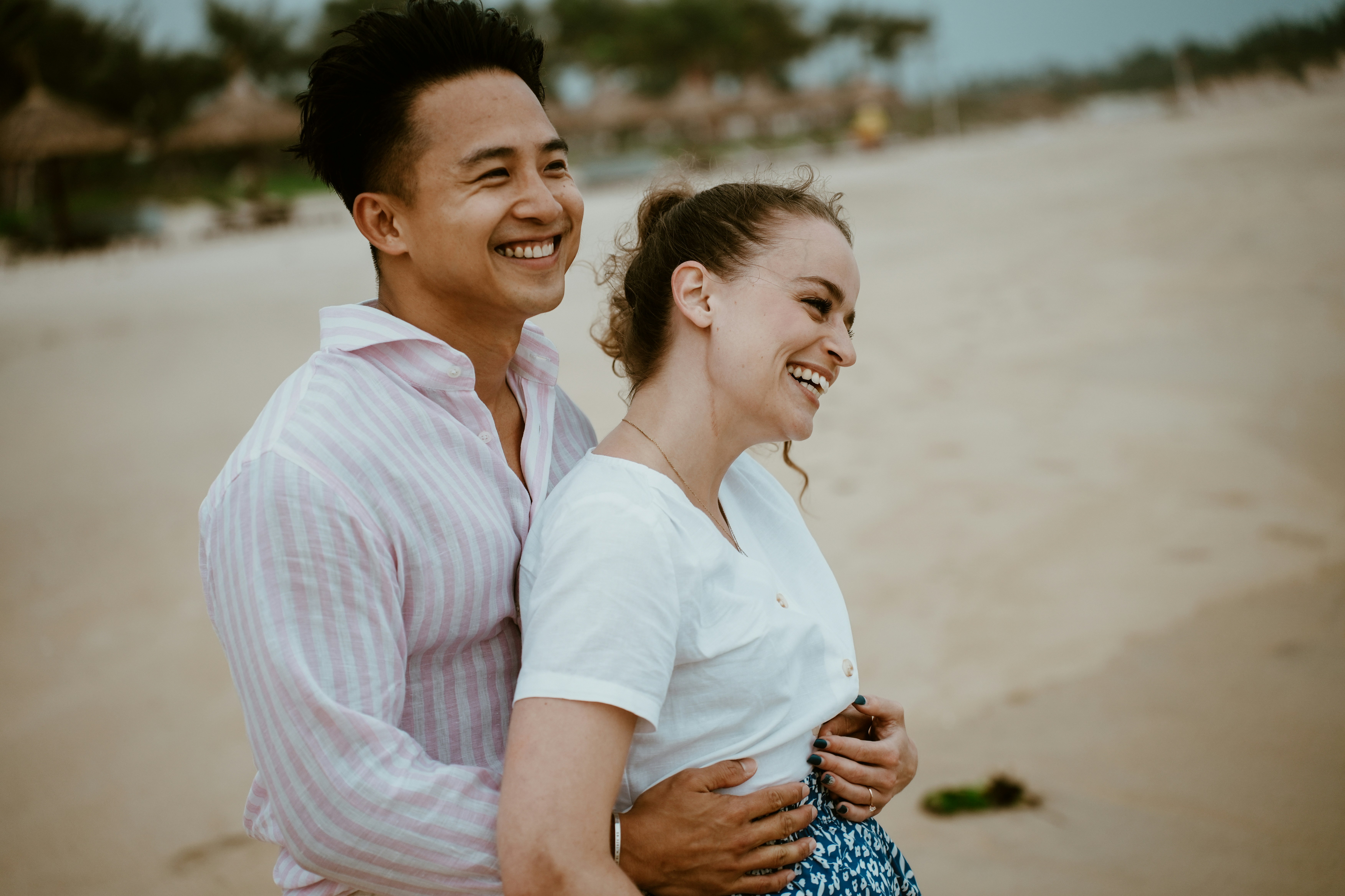 A couple smiling on a sandy beach