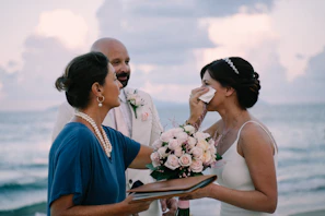 Bride crying while officiant wipes her tears