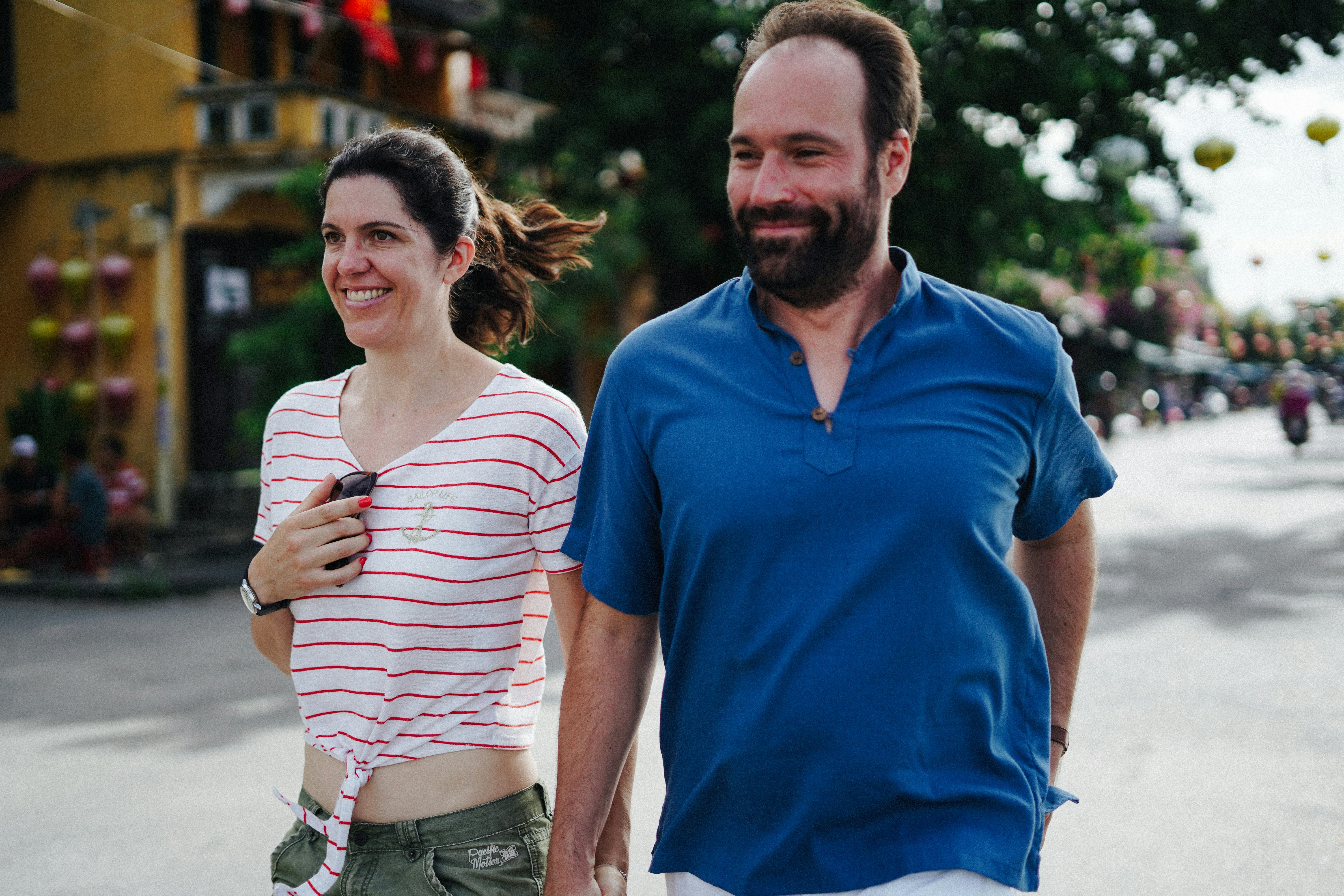 Un couple marchant main dans la main dans une rue