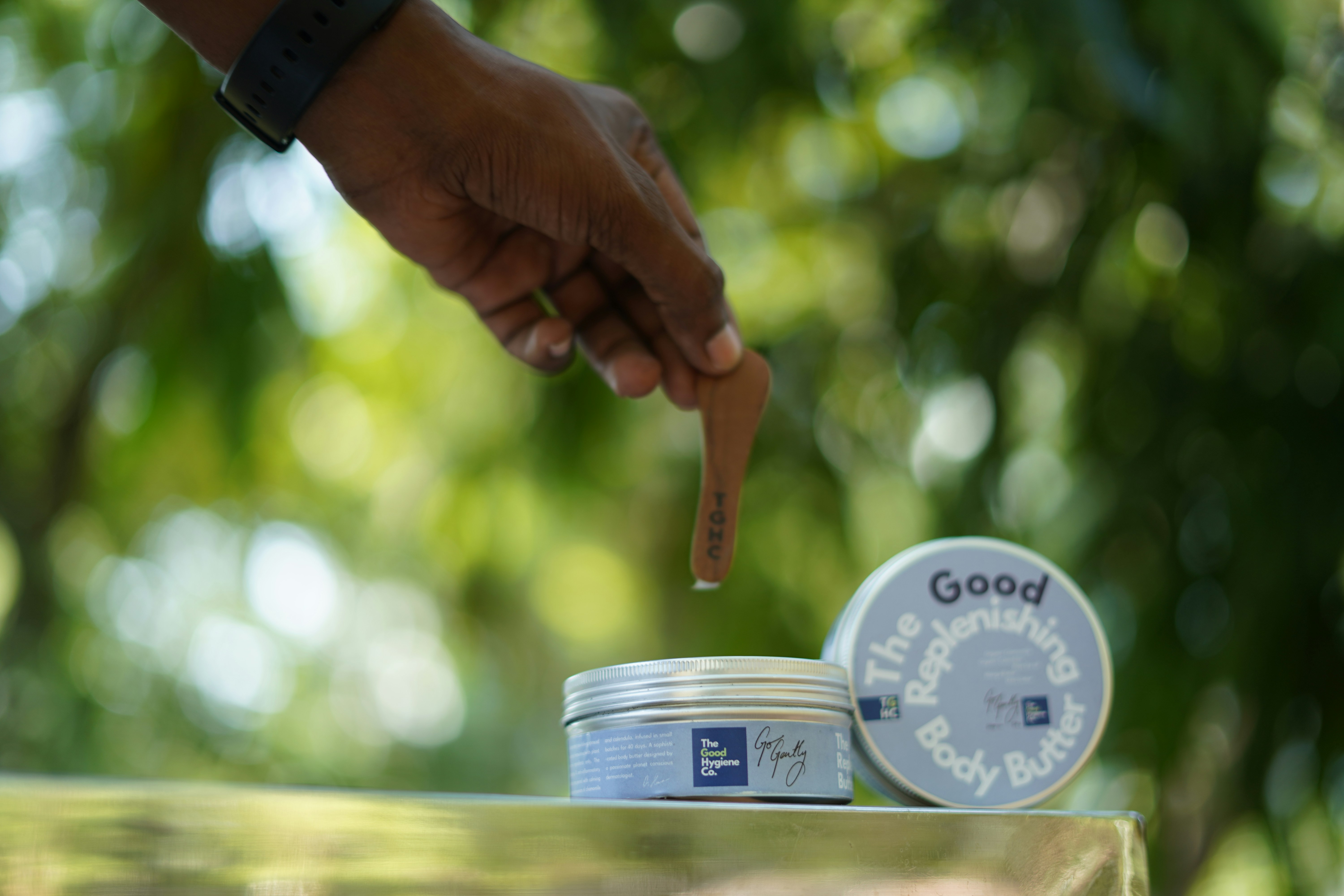 Hand holding a small brown object over tins