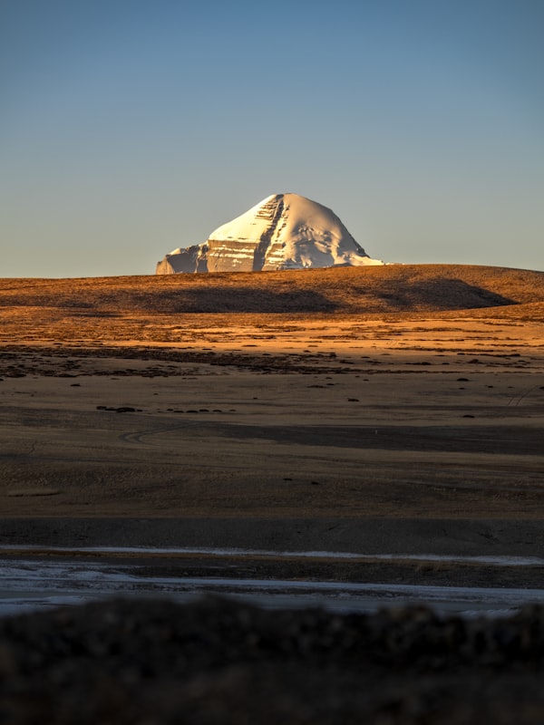 Sacred Mount Kailash snow-capped peak illuminated by golden hour light in Western Tibet