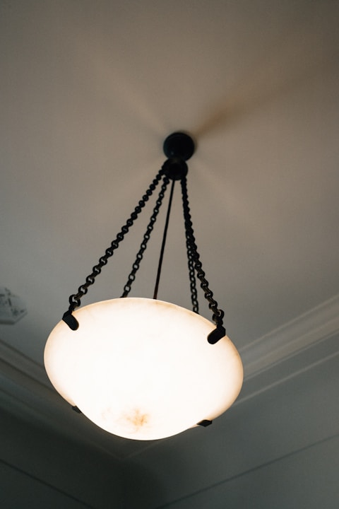 An antique chandelier hangs from a ceiling.