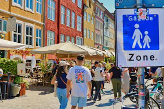 People walking in a pedestrian zone with colorful buildings.