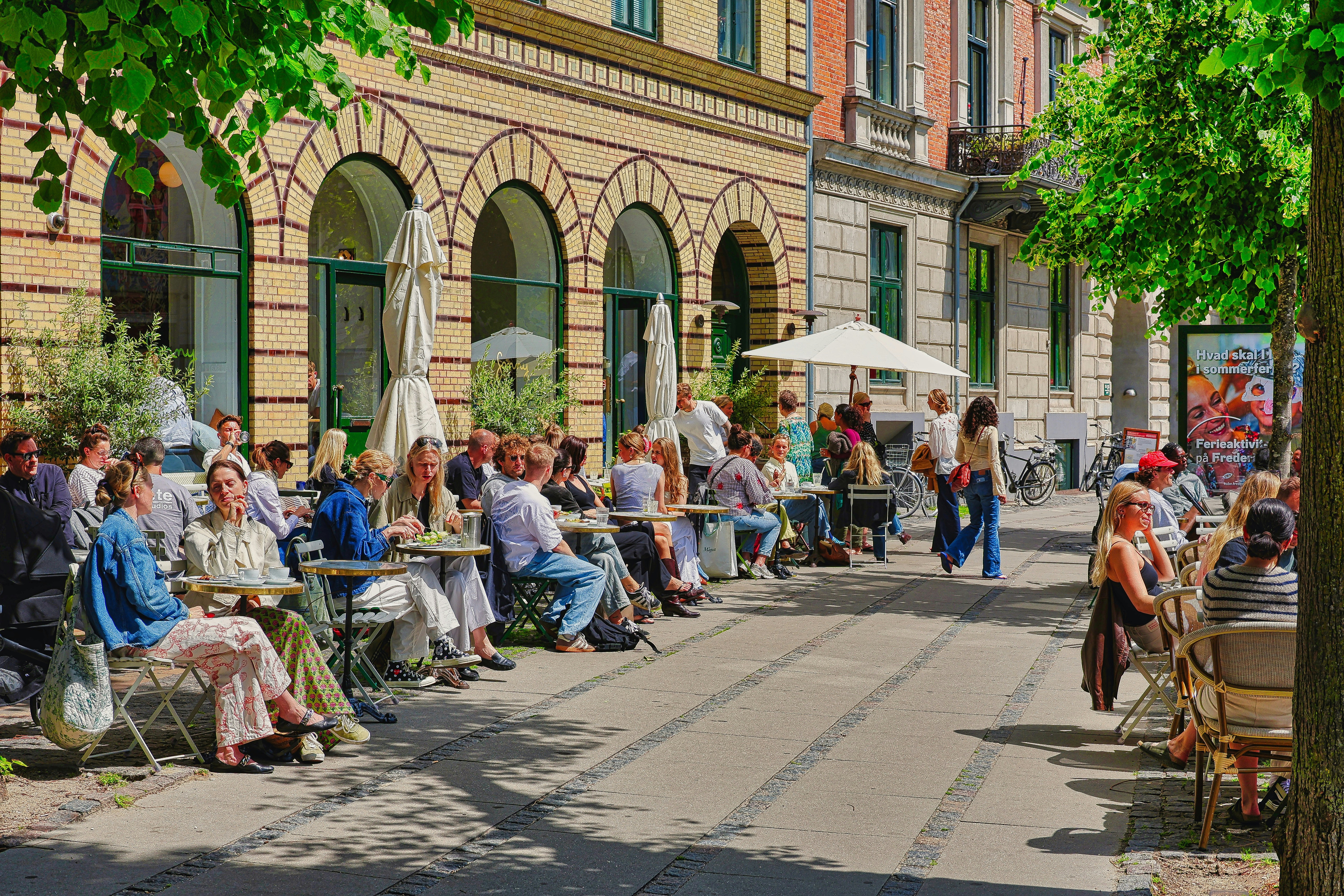 Cyclists, pedestrians, and terraces animate this wide avenue, where moderate traffic gives way to conviviality.