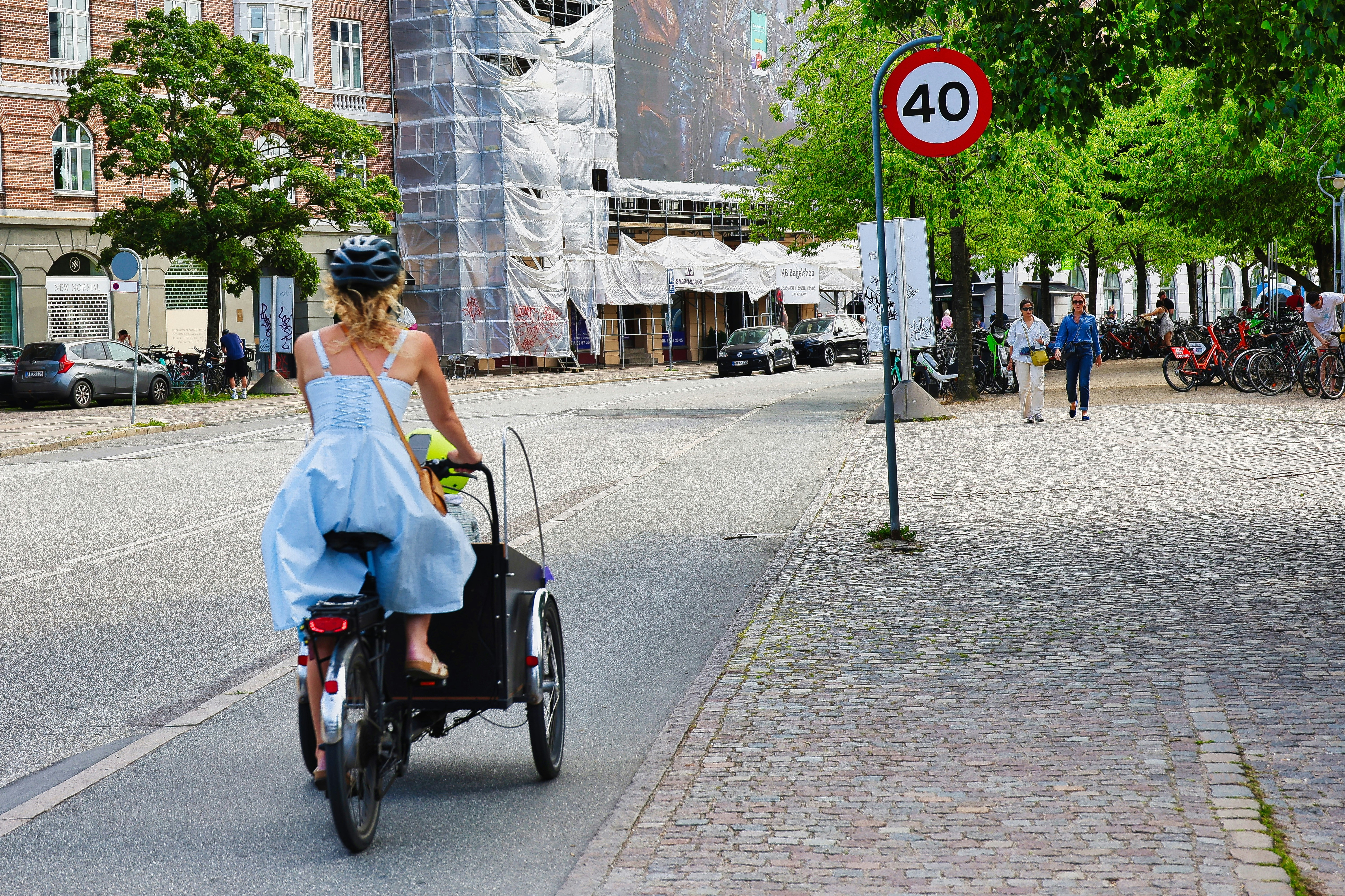 Mulher anda de bicicleta carga pela rua da cidade
