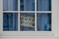 Gone fishing sign hanging in a window.