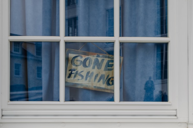 Gone fishing sign hanging in a window.