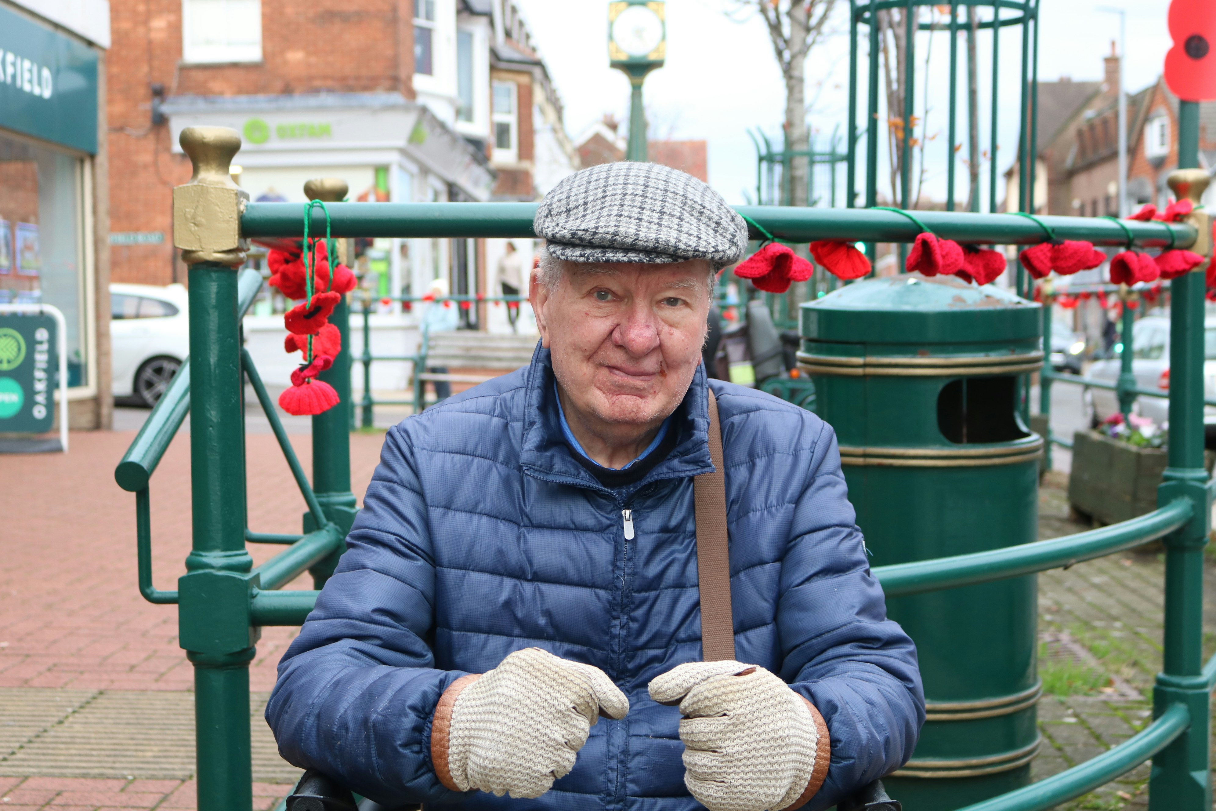 Elderly man wearing a flat cap and puffer jacket.