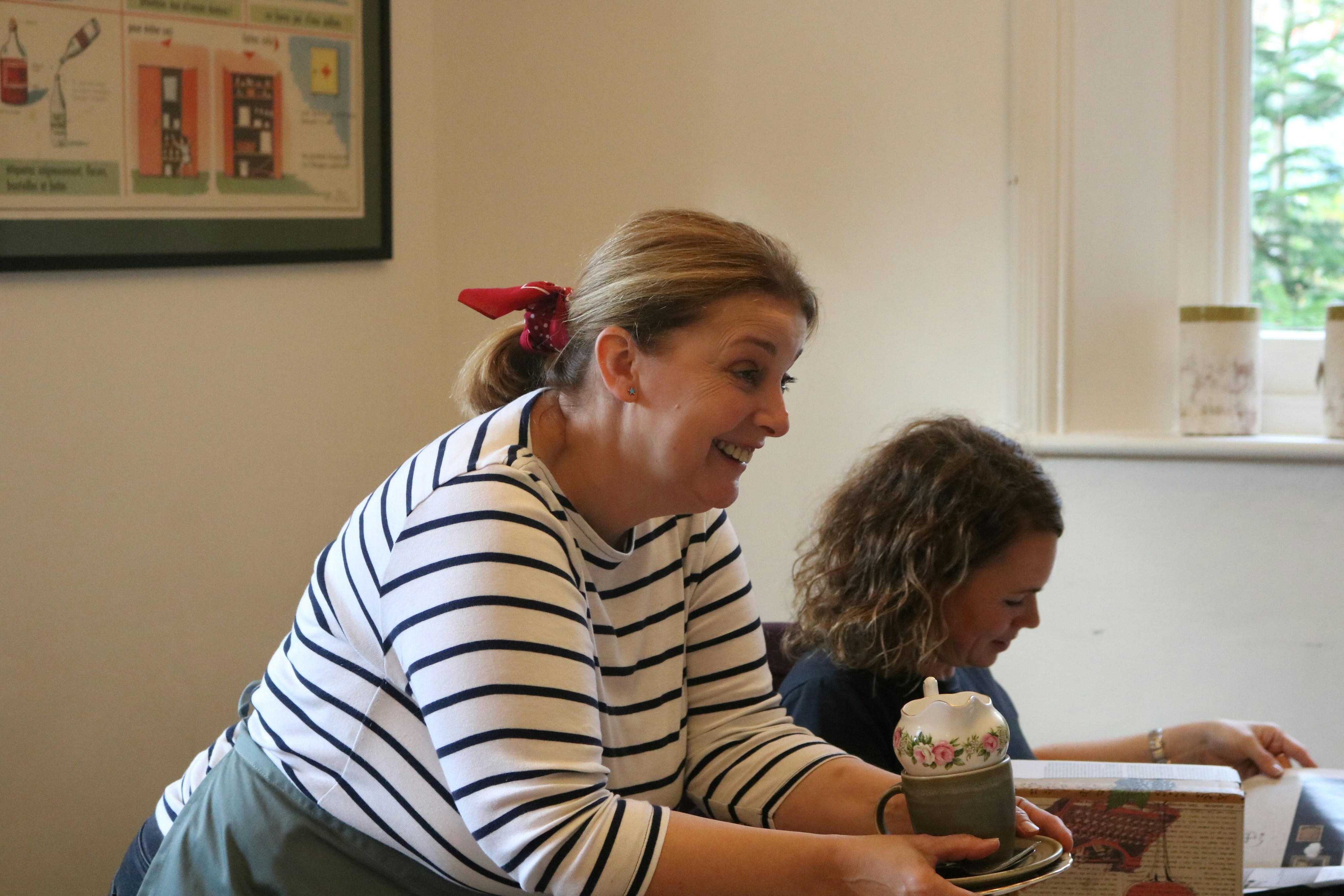 Woman in striped shirt holding a decorative object.