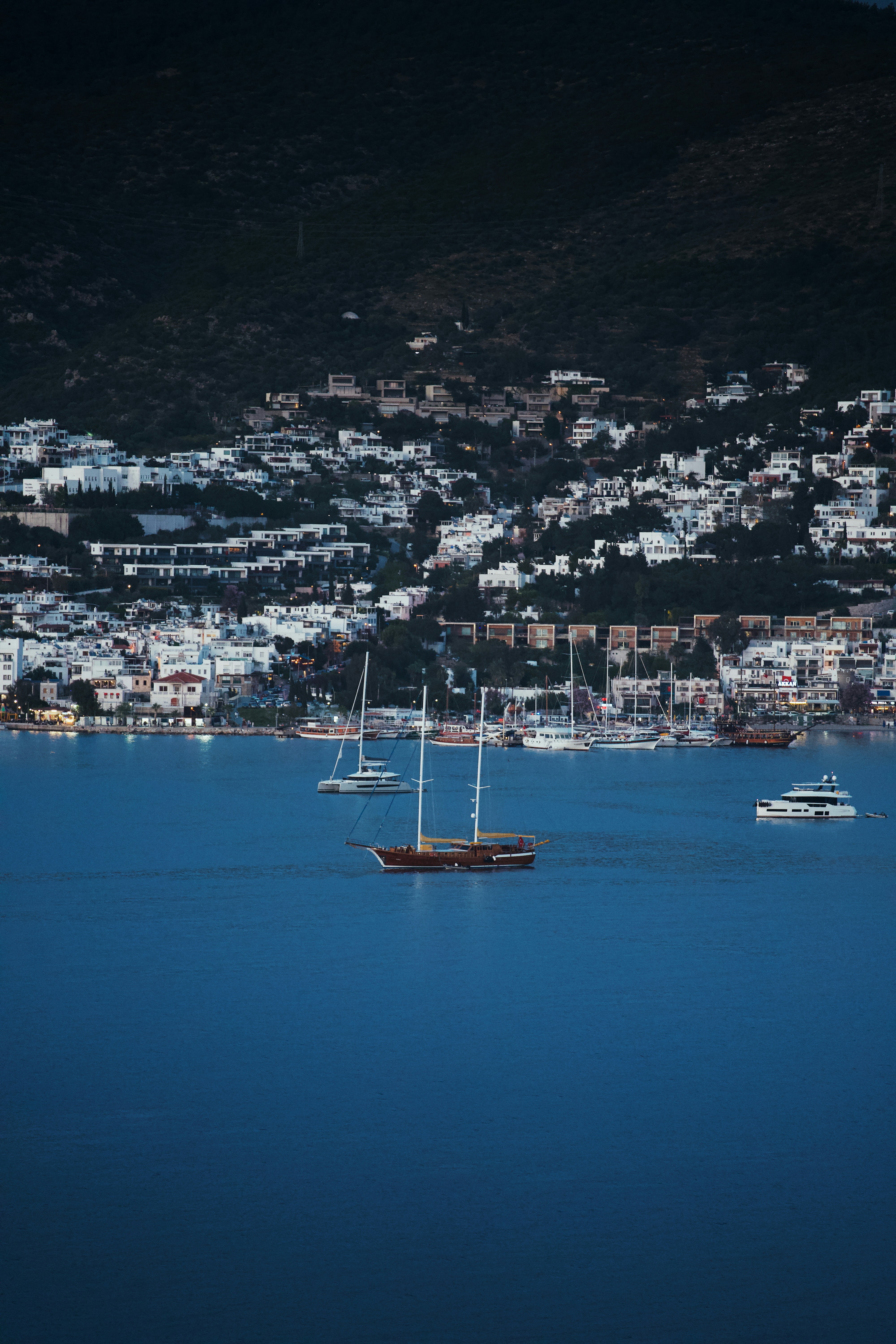 Sailboats and yachts on a deep blue sea near town