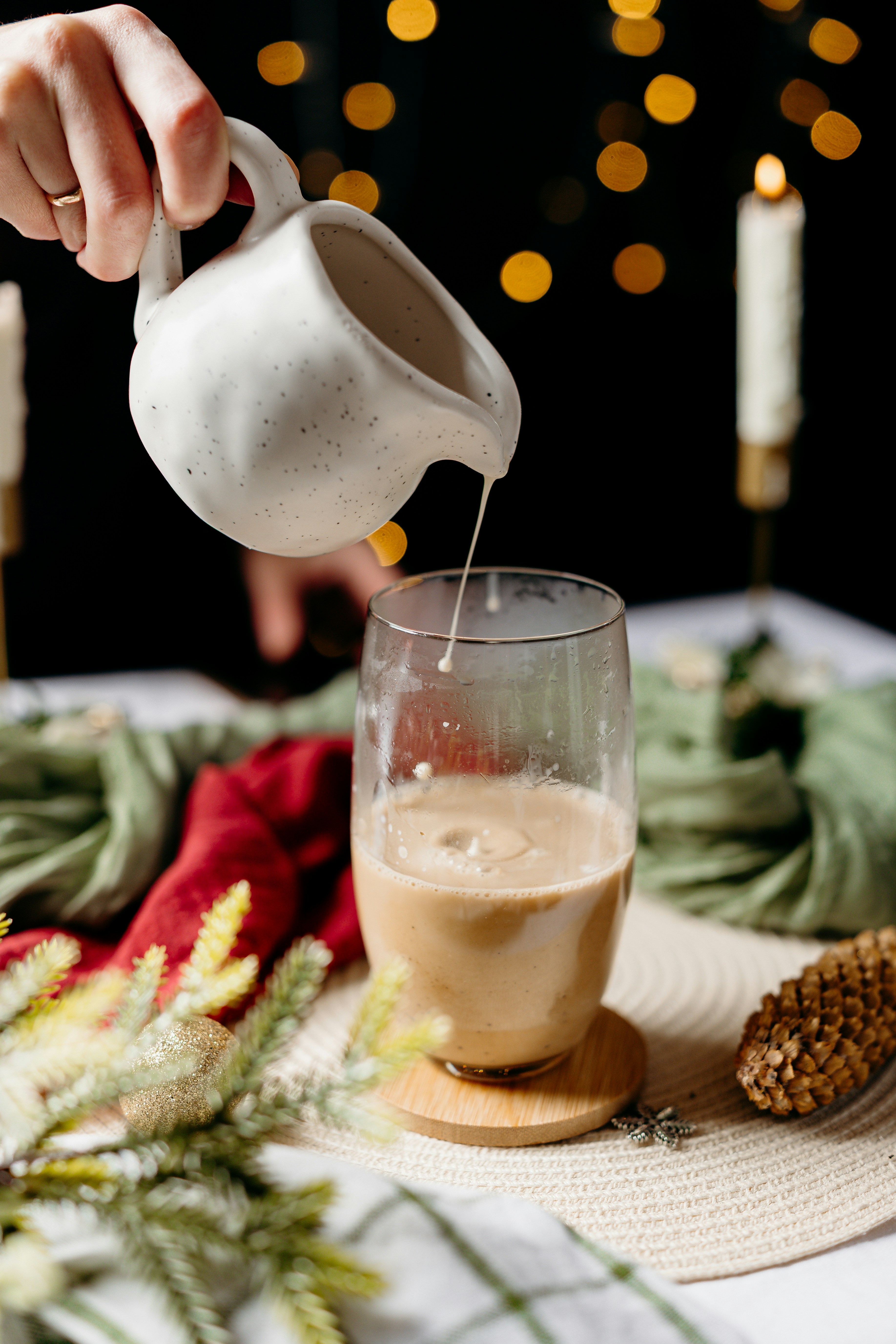Cream being poured into a glass of coffee.