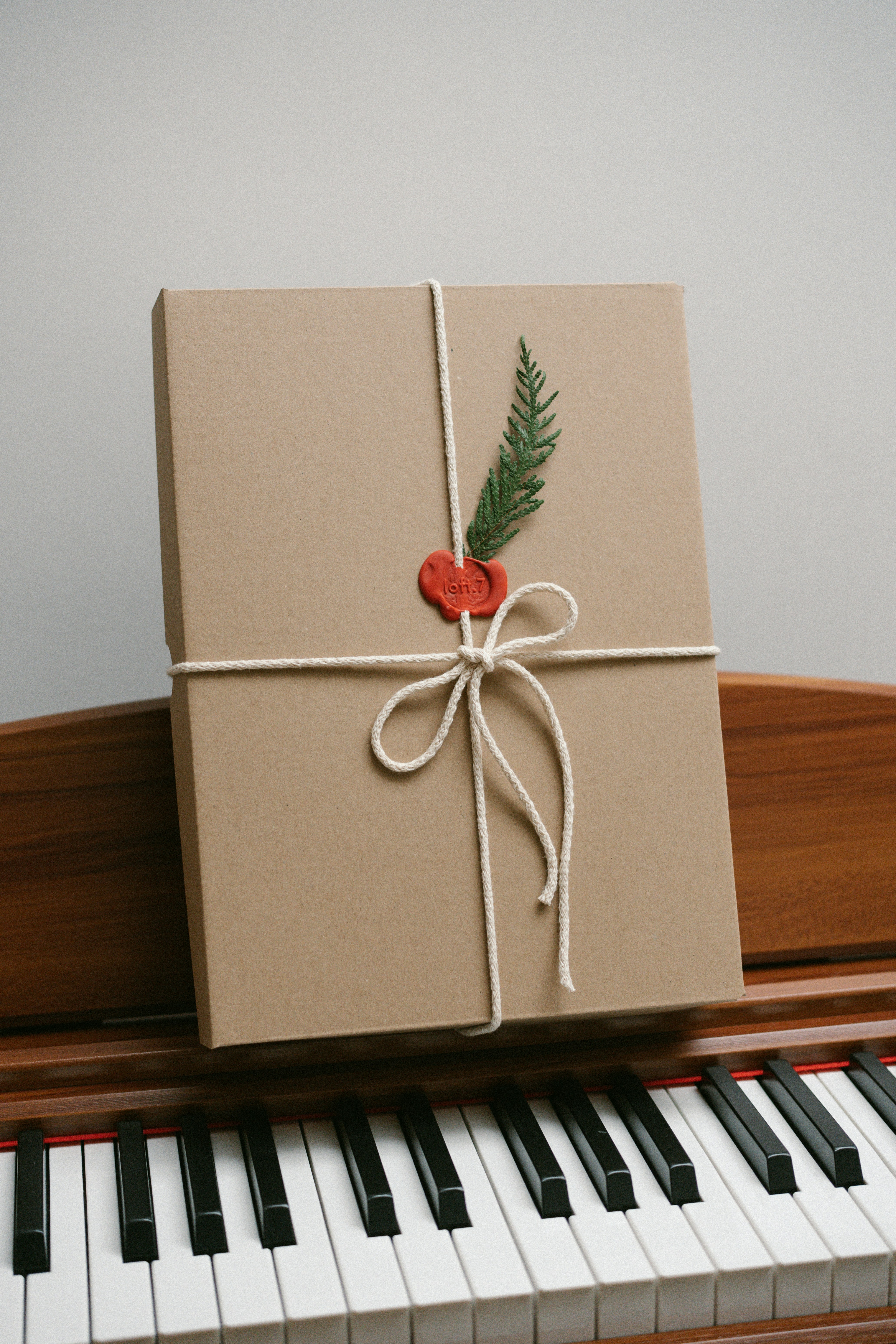 Gift box with greenery and wax seal on piano keys