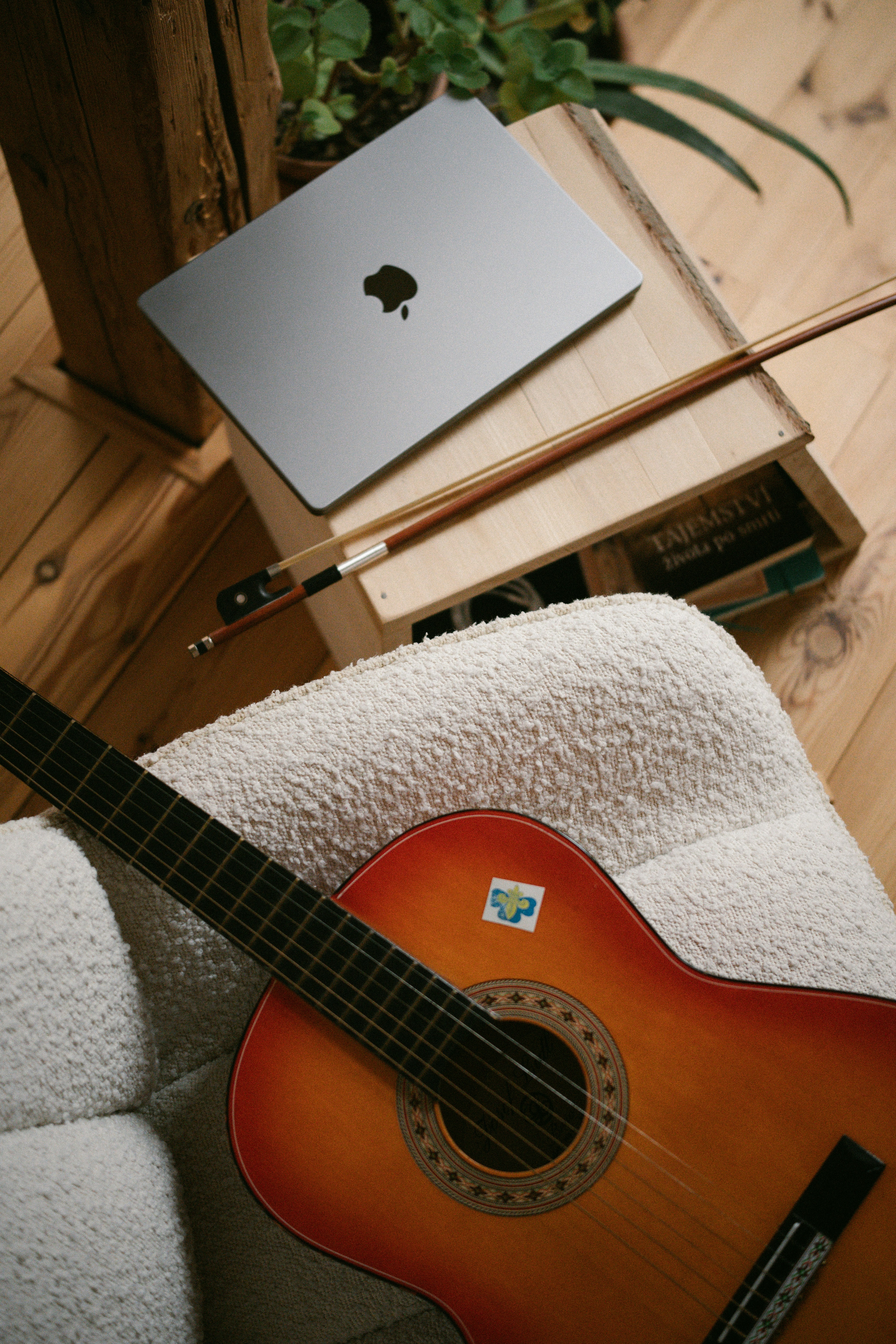Laptop and guitar on a wooden crate
