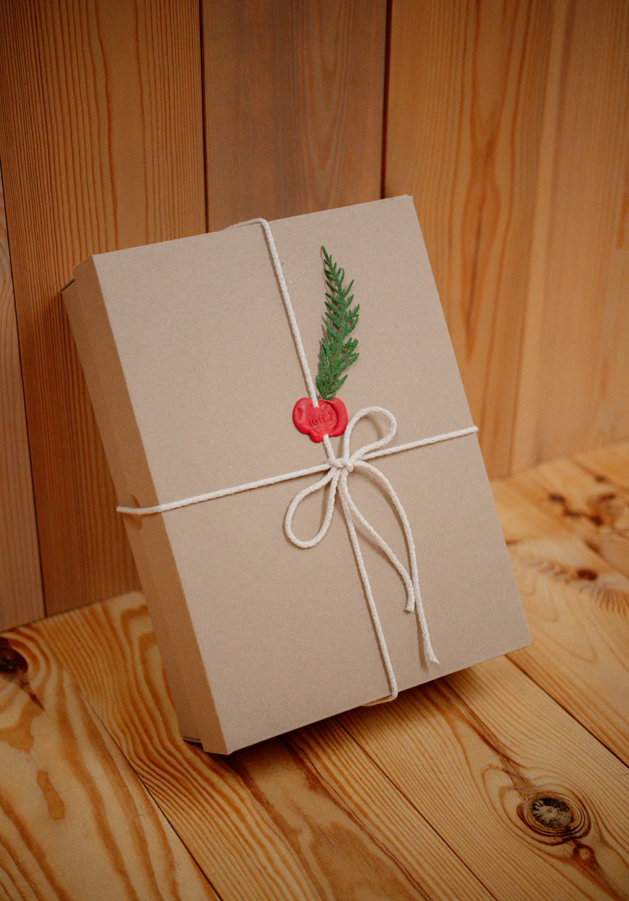 Gift box wrapped in kraft paper tied with twine and greenery