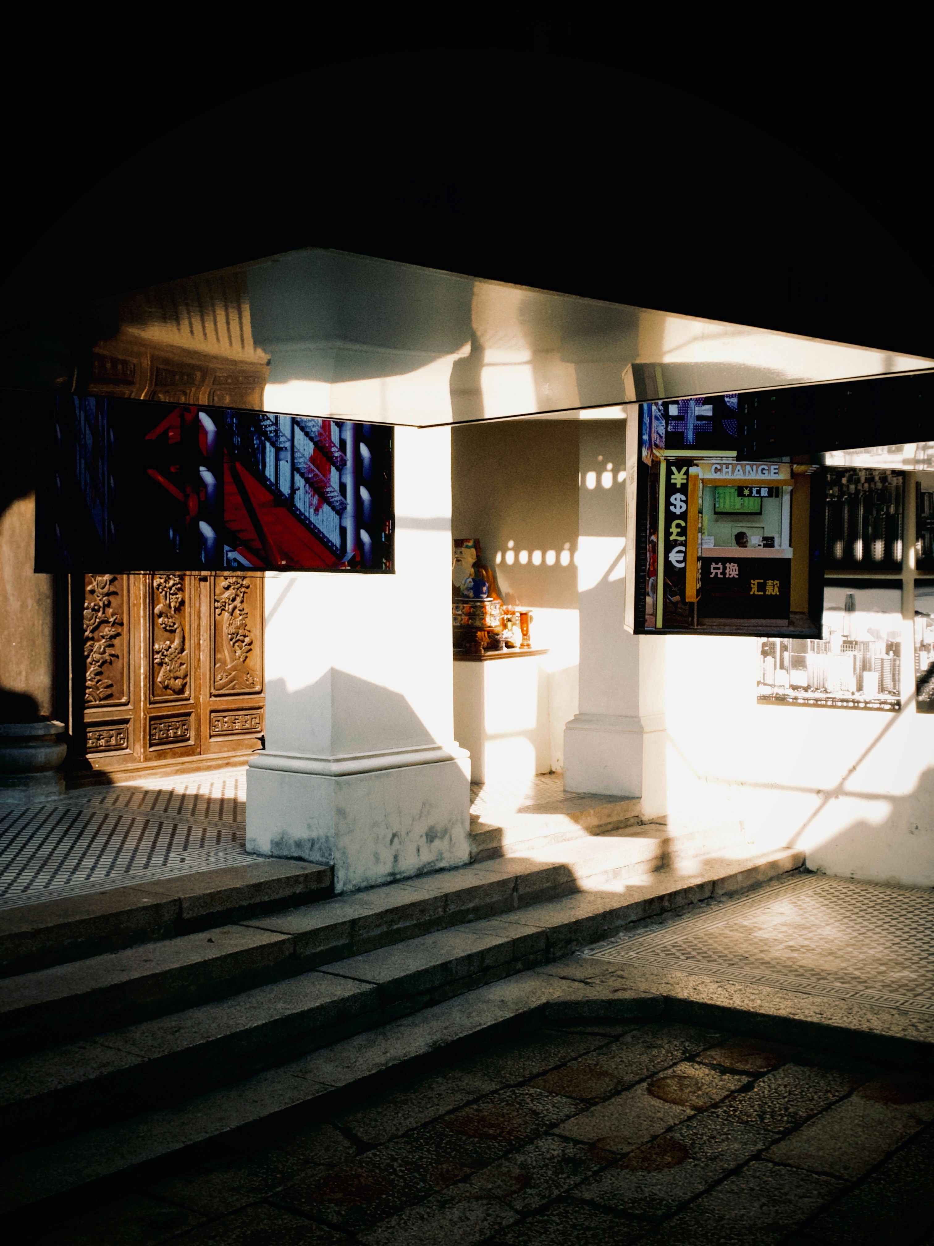 Sunlit architectural entryway with decorative wooden doors.