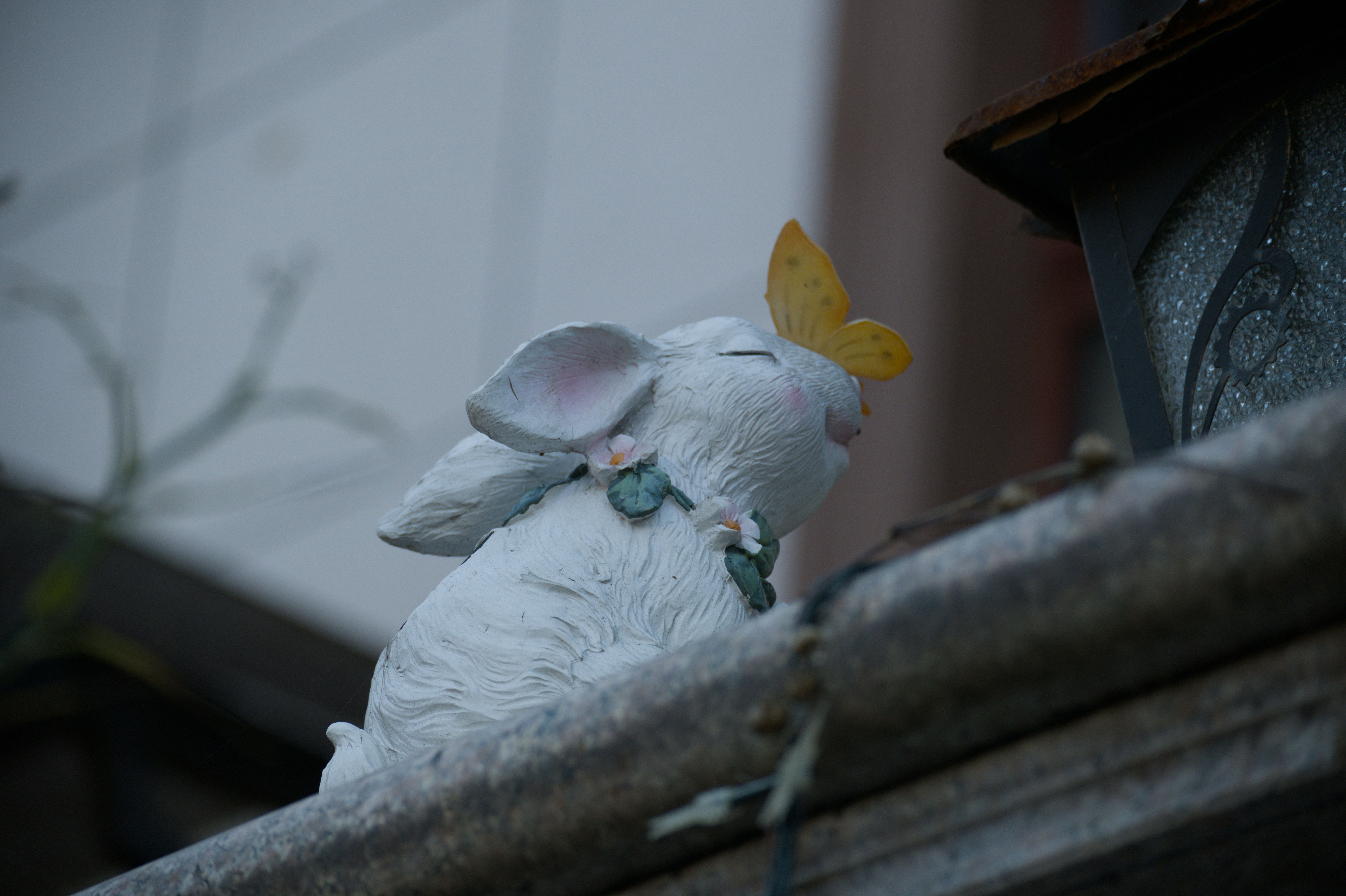 Figurita de conejo blanco con mariposa amarilla en la nariz