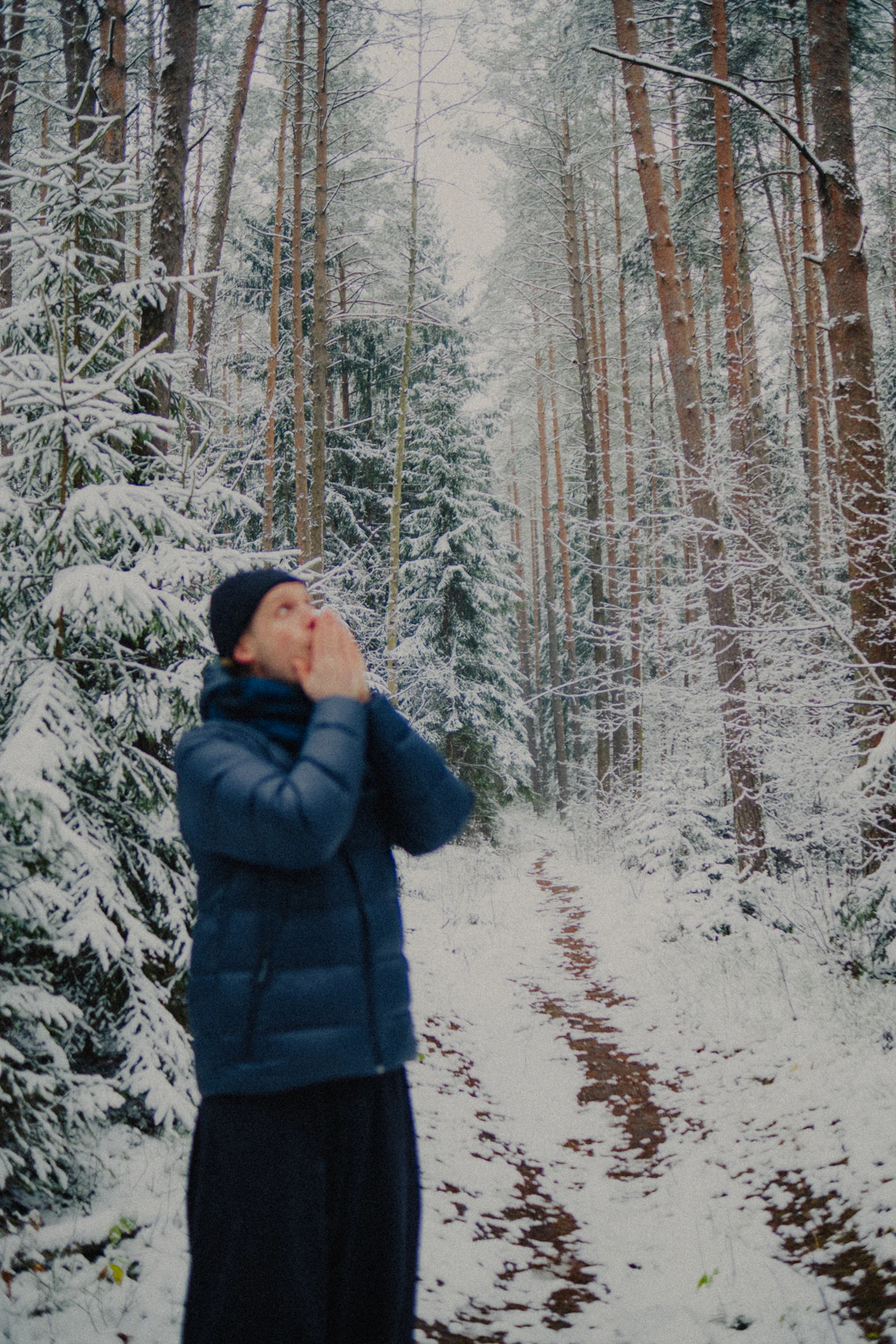 Mann atmet in einem winterlichen Wald bewusst frische Luft ein