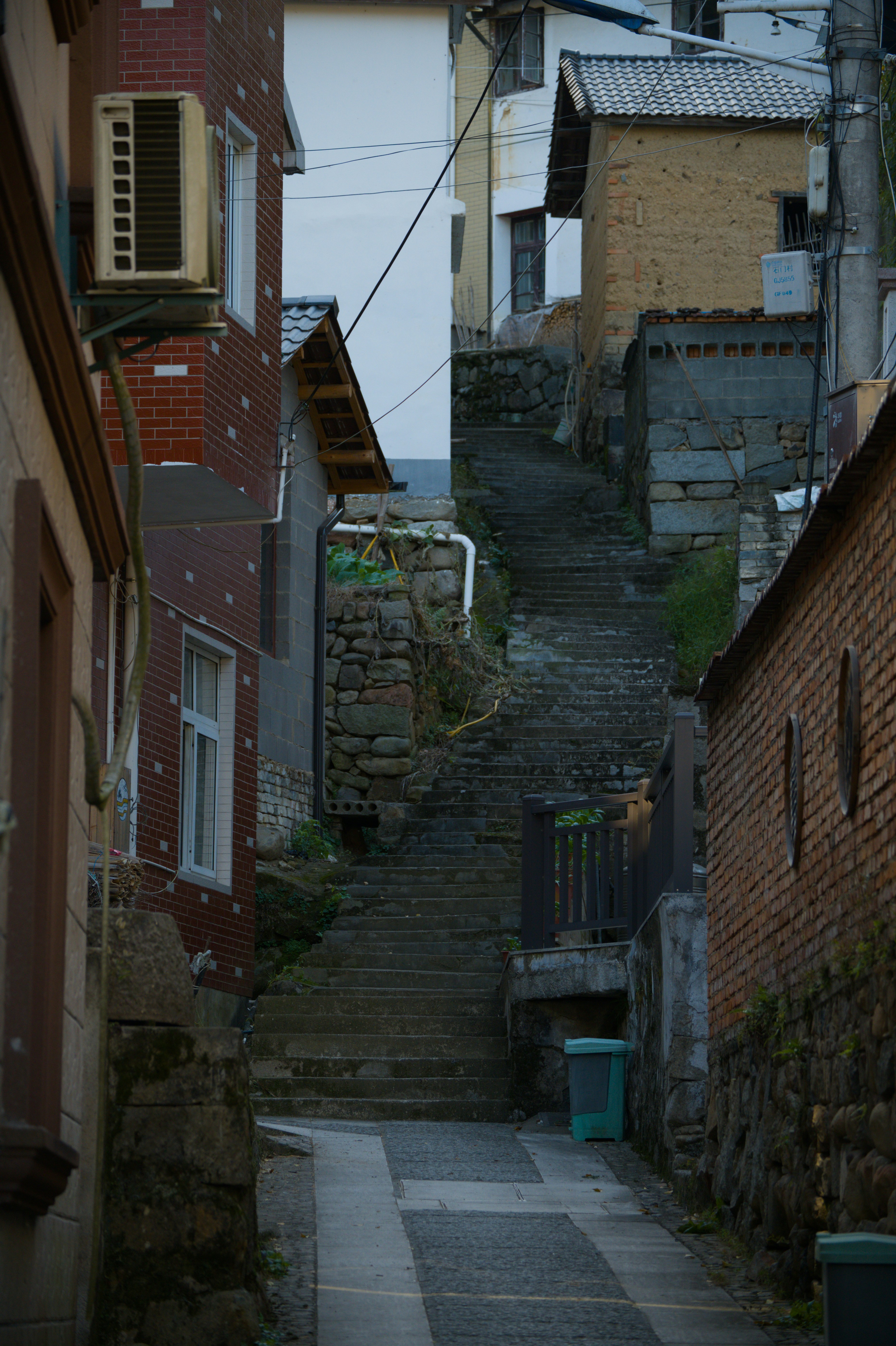 Empinada escalera de piedra entre casas antiguas en un pueblo.