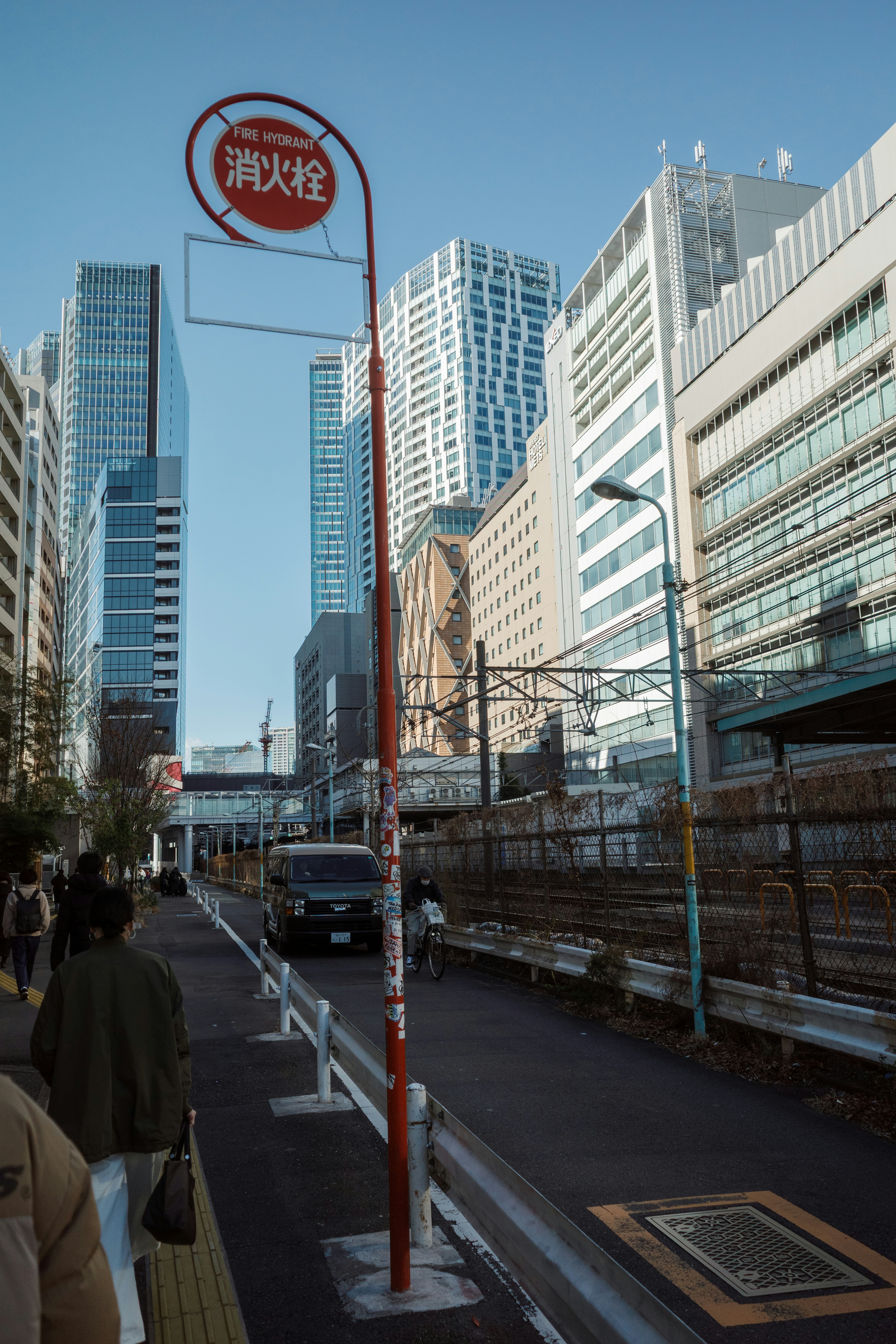 City street with modern buildings and train tracks.