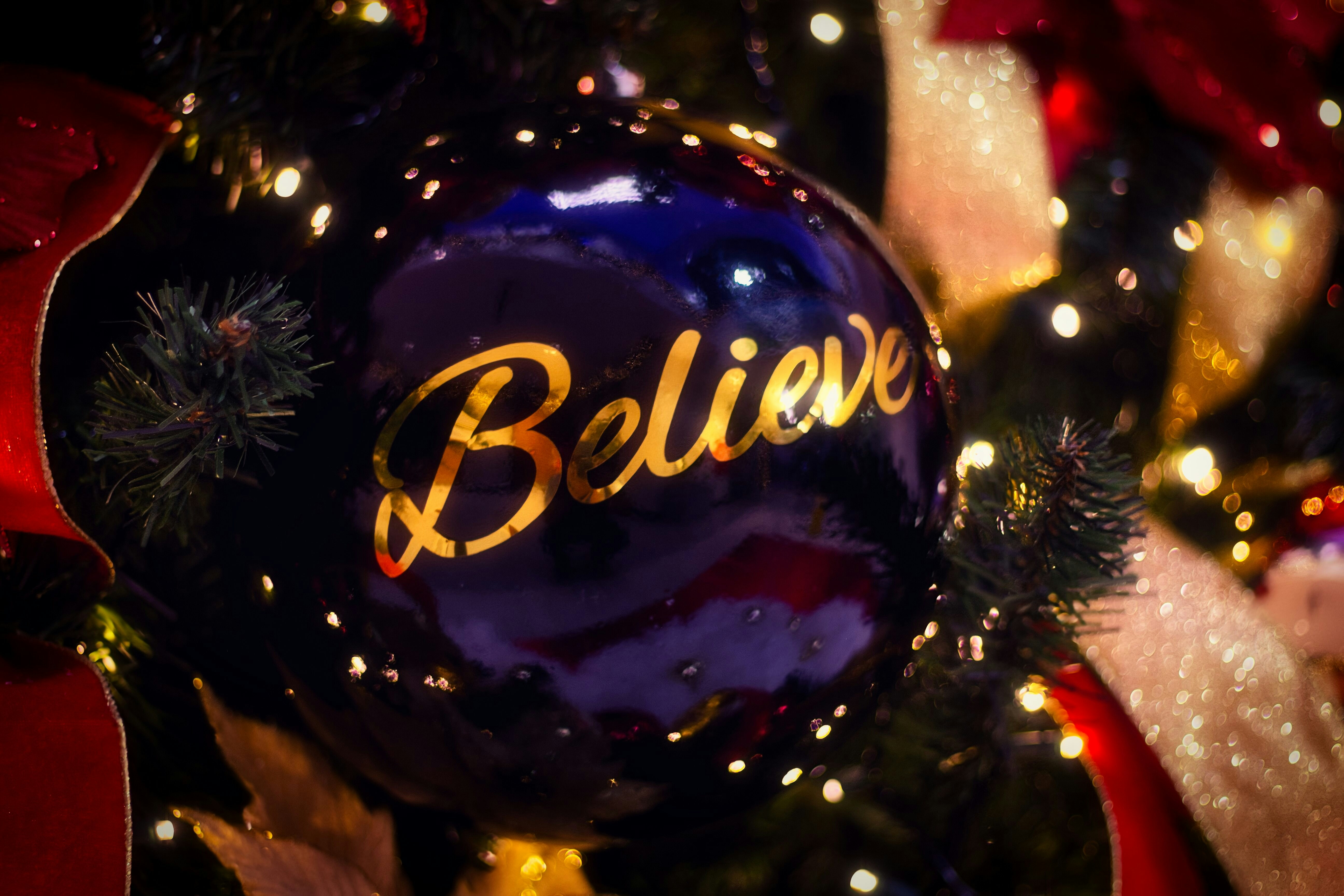 Dark blue christmas ornament with "believe" written on it