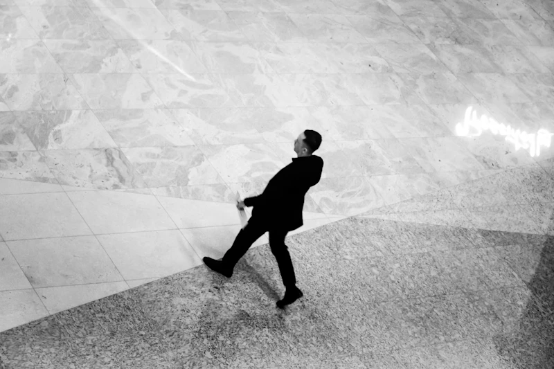 Uomo in abito che cammina su un pavimento di marmo