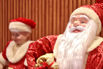 Santa claus figure with a child in background