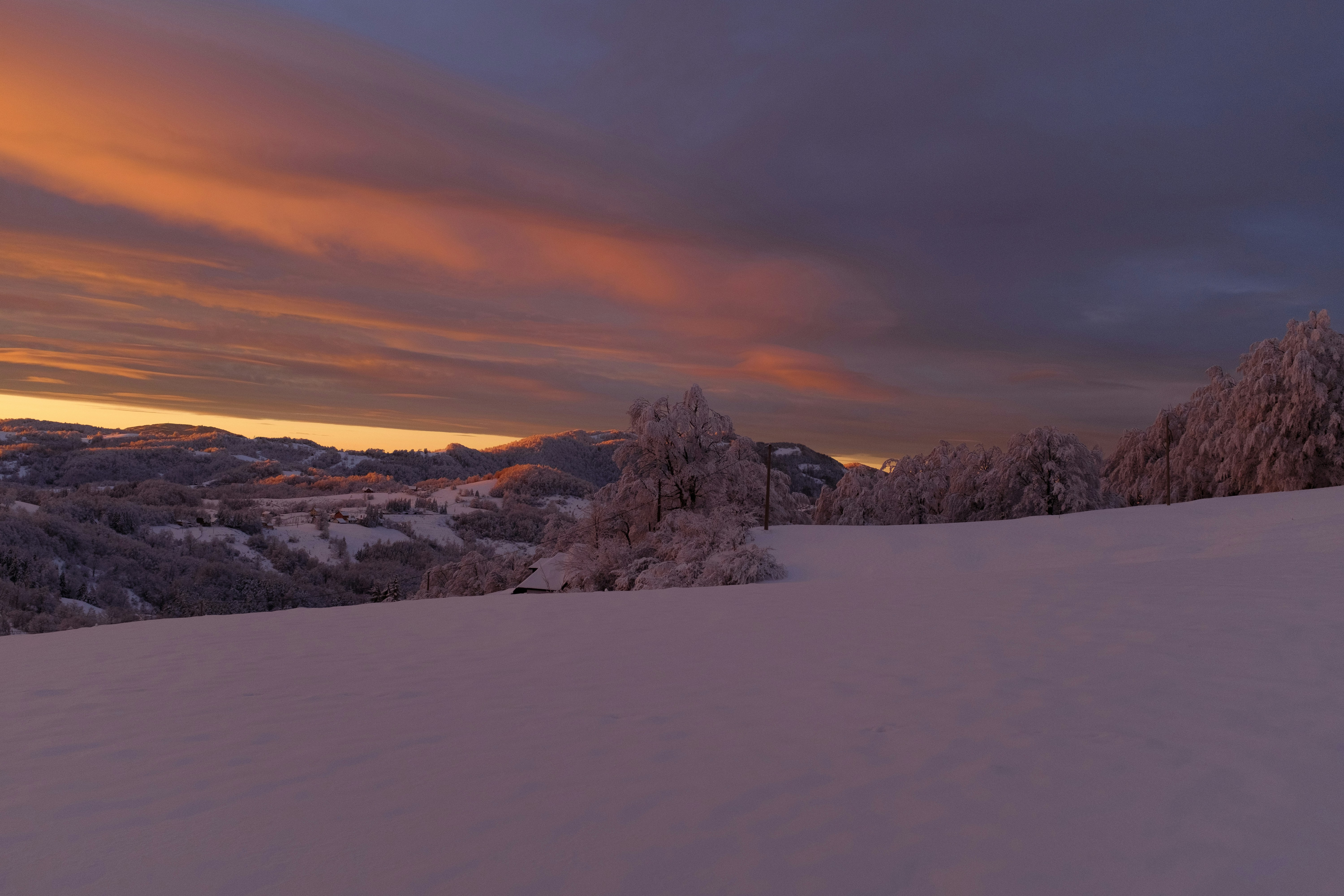 Snowy landscape with colorful sunset sky