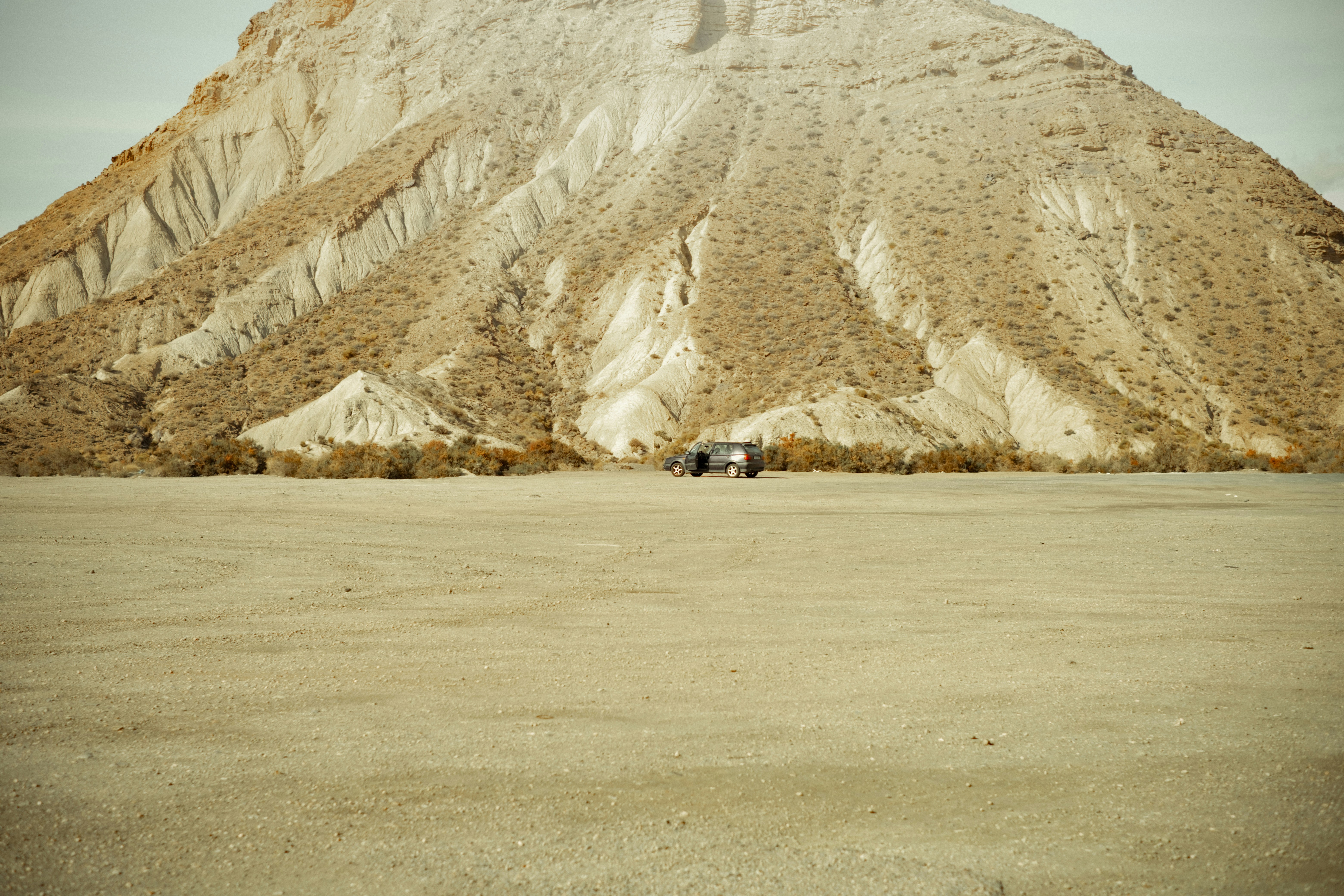 A vast desert landscape with a large mountain.