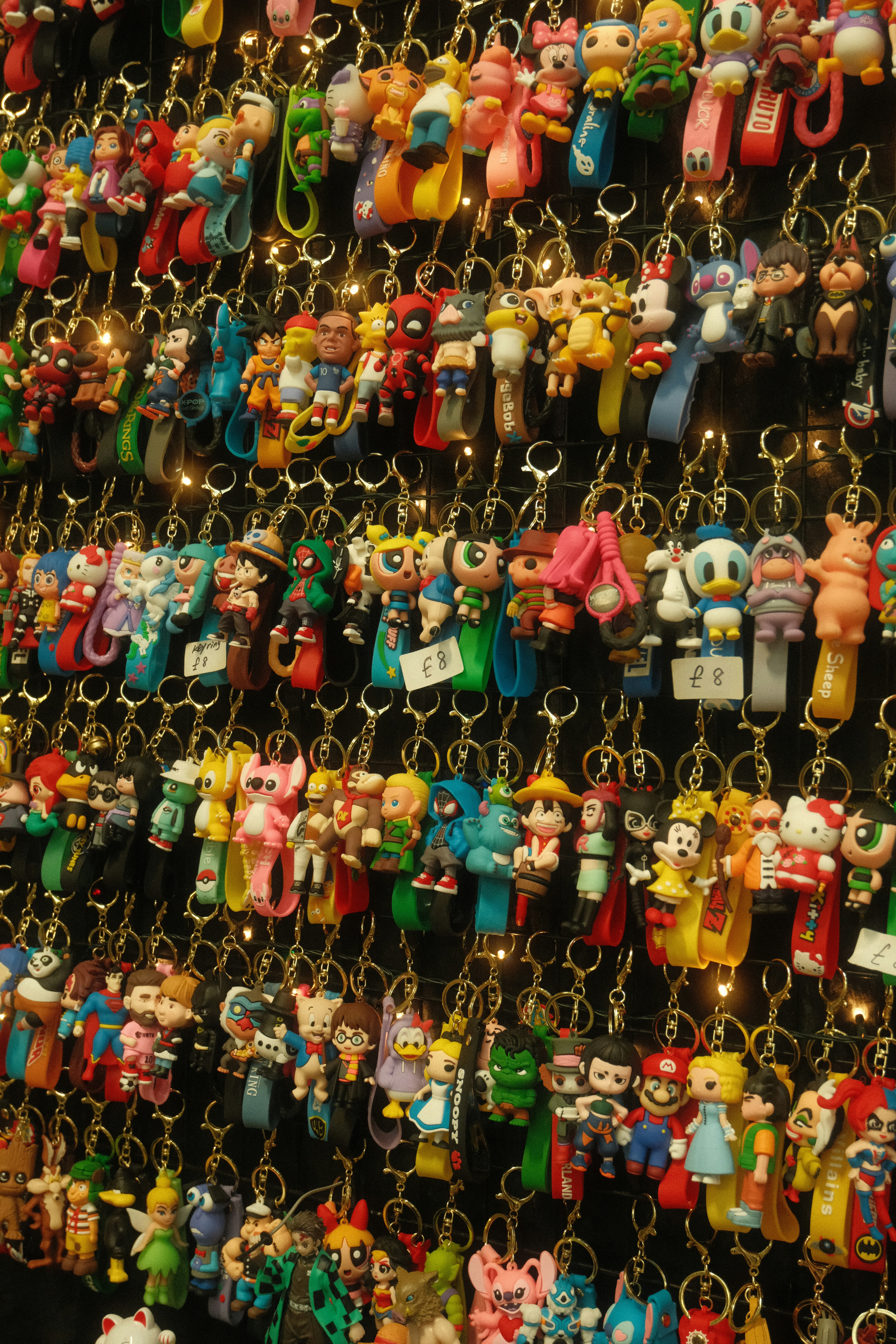 Wall display of many colorful cartoon character keychains.