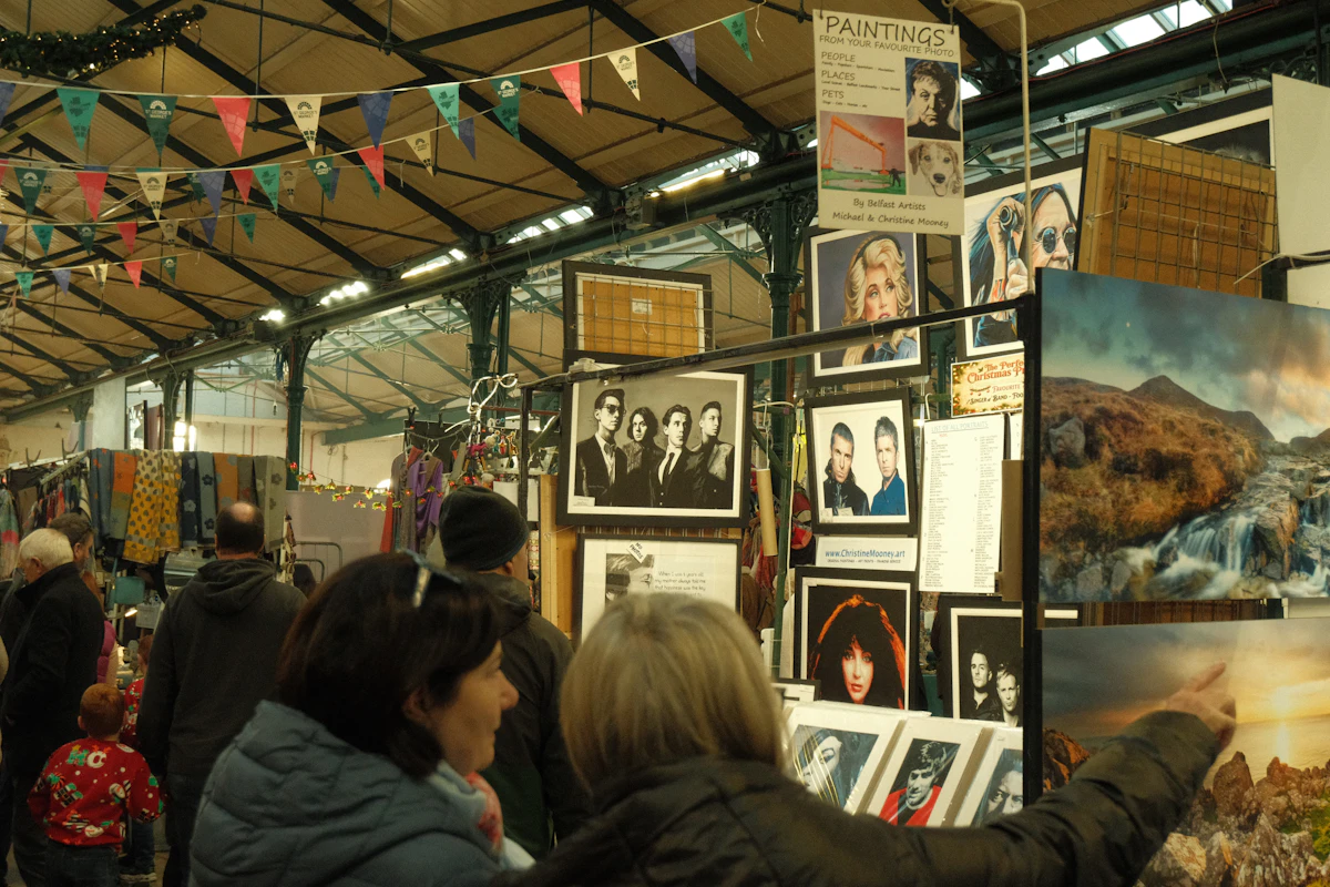 People browsing artwork displayed at a creative market