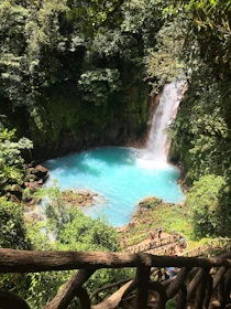 Turquoise waterfall cascading into a jungle pool