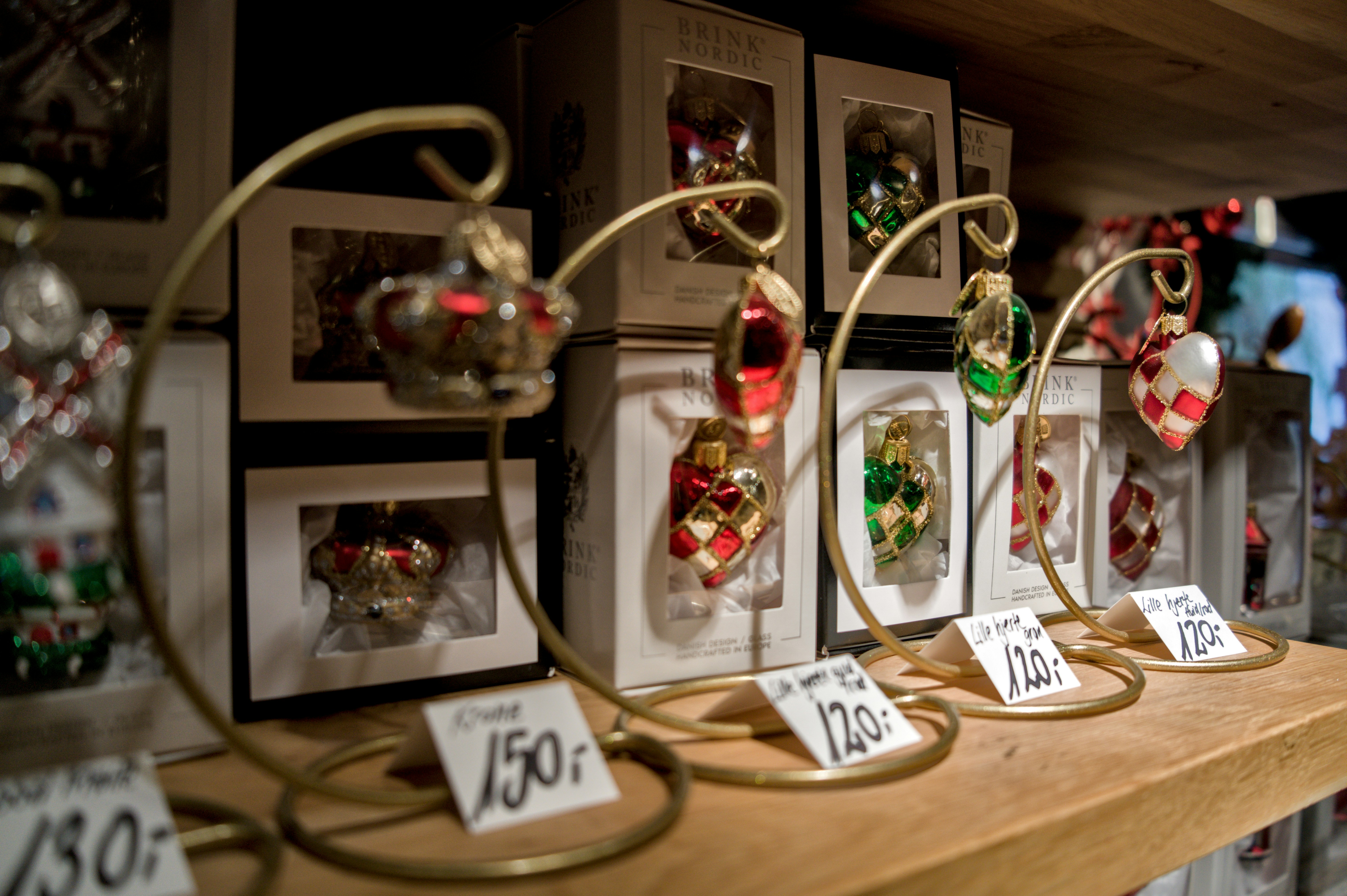 Christmas ornaments displayed on a shelf with price tags.
