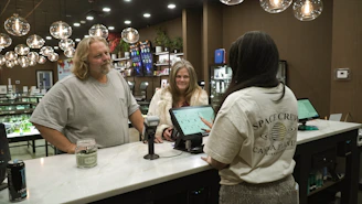 Customers interact with staff at a dispensary counter.