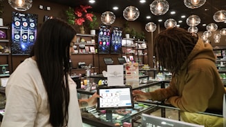 Two people interacting with a tablet at a counter.