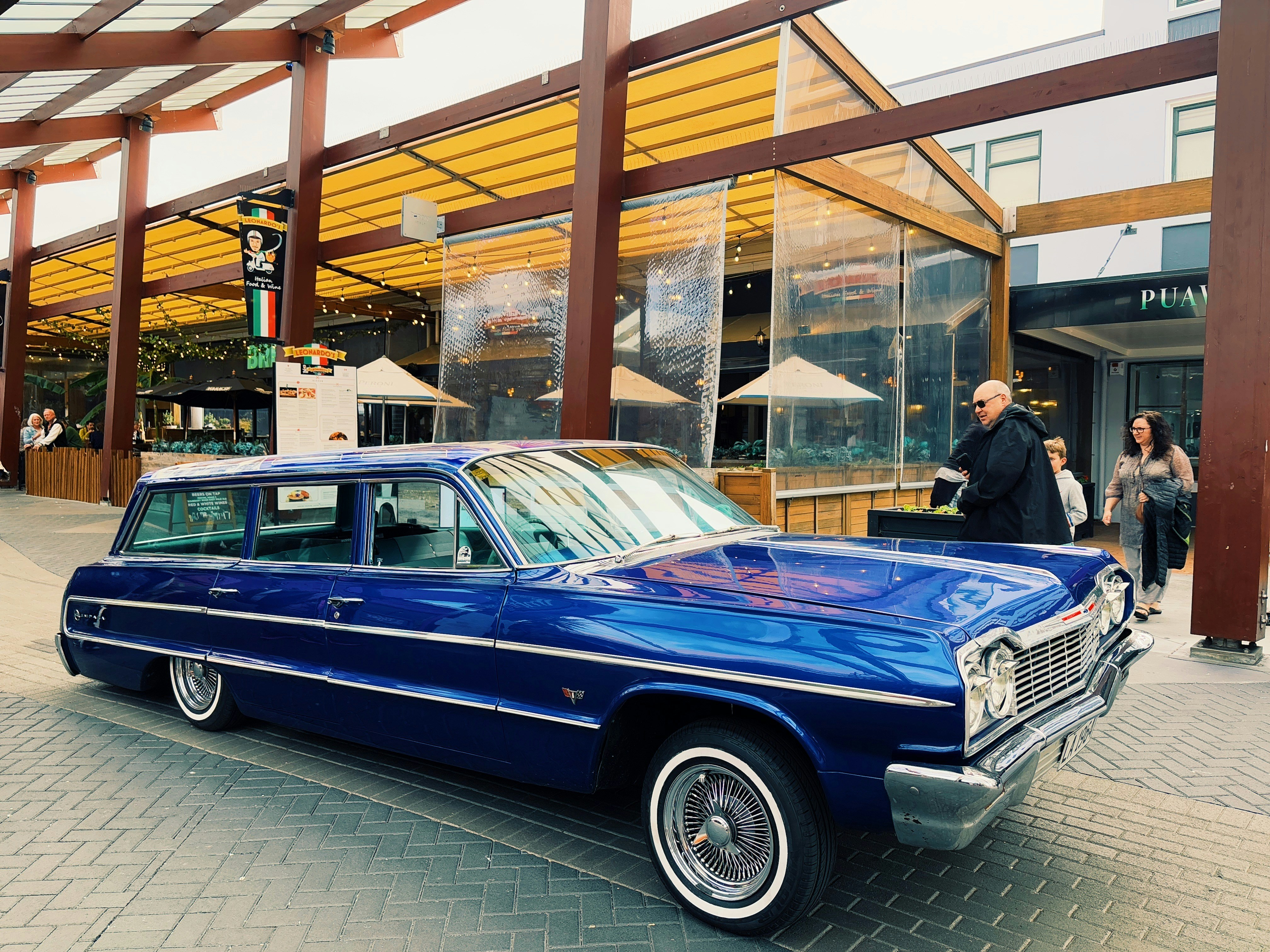 A shiny blue vintage station wagon parked outdoors.