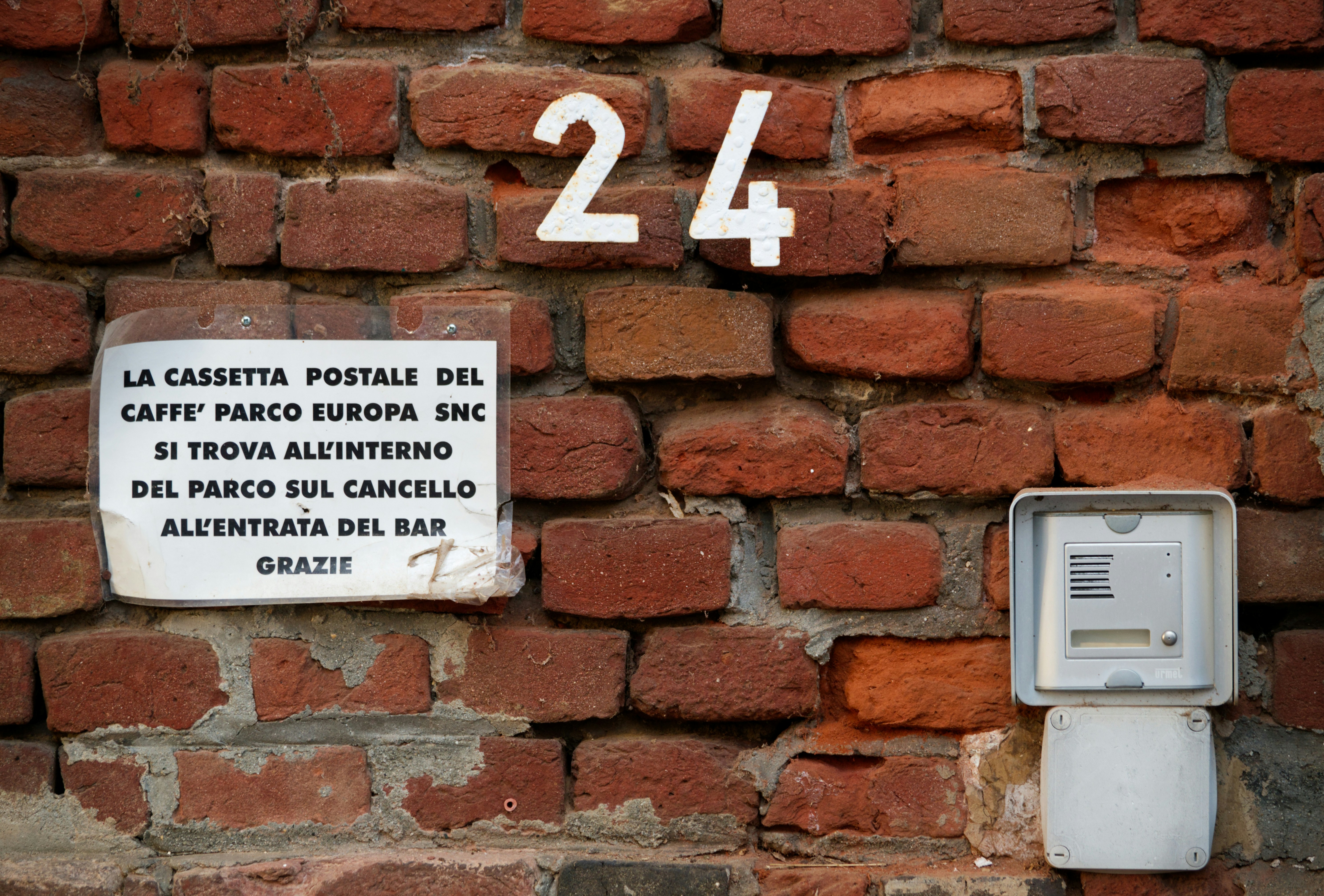 Brick wall with house number 24 and mailbox sign.