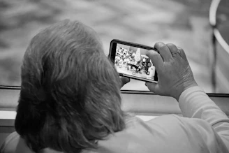 Elderly person holding smartphone watching video