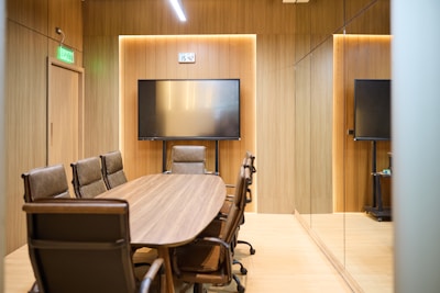 Modern conference room with oval table and chairs.