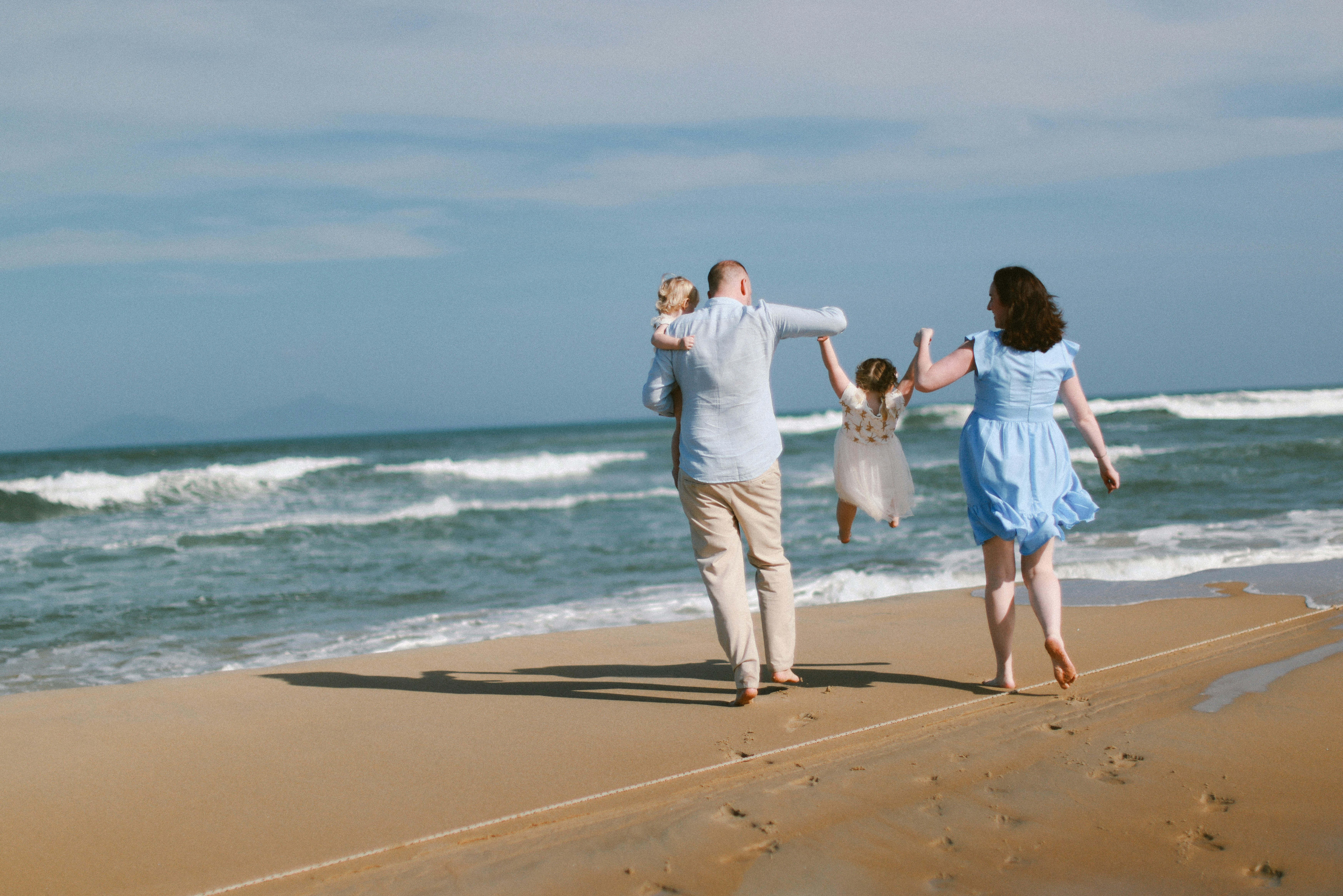 Family walking on beach with ocean waves