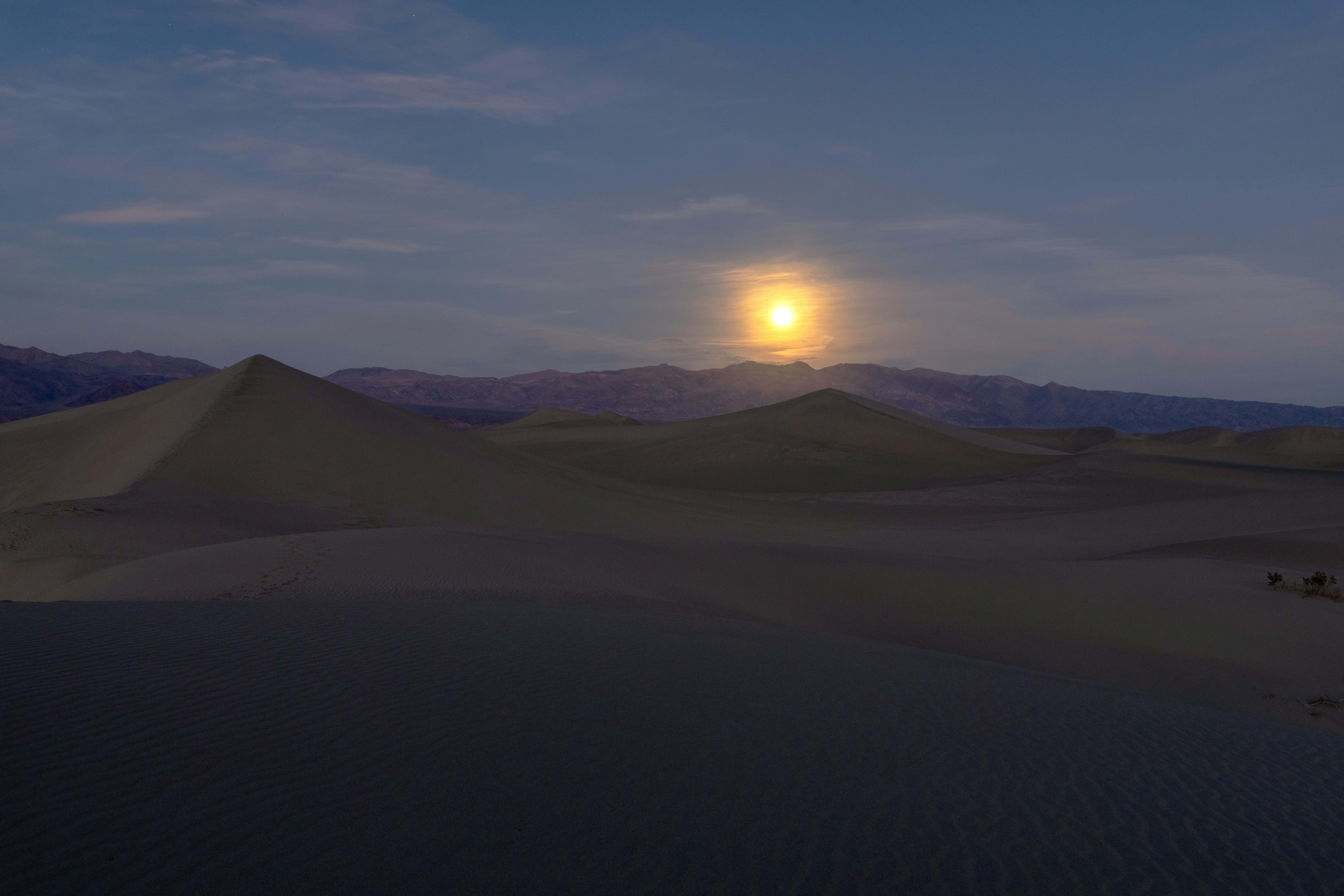 Soleil se couchant sur de vastes dunes de sable désertiques