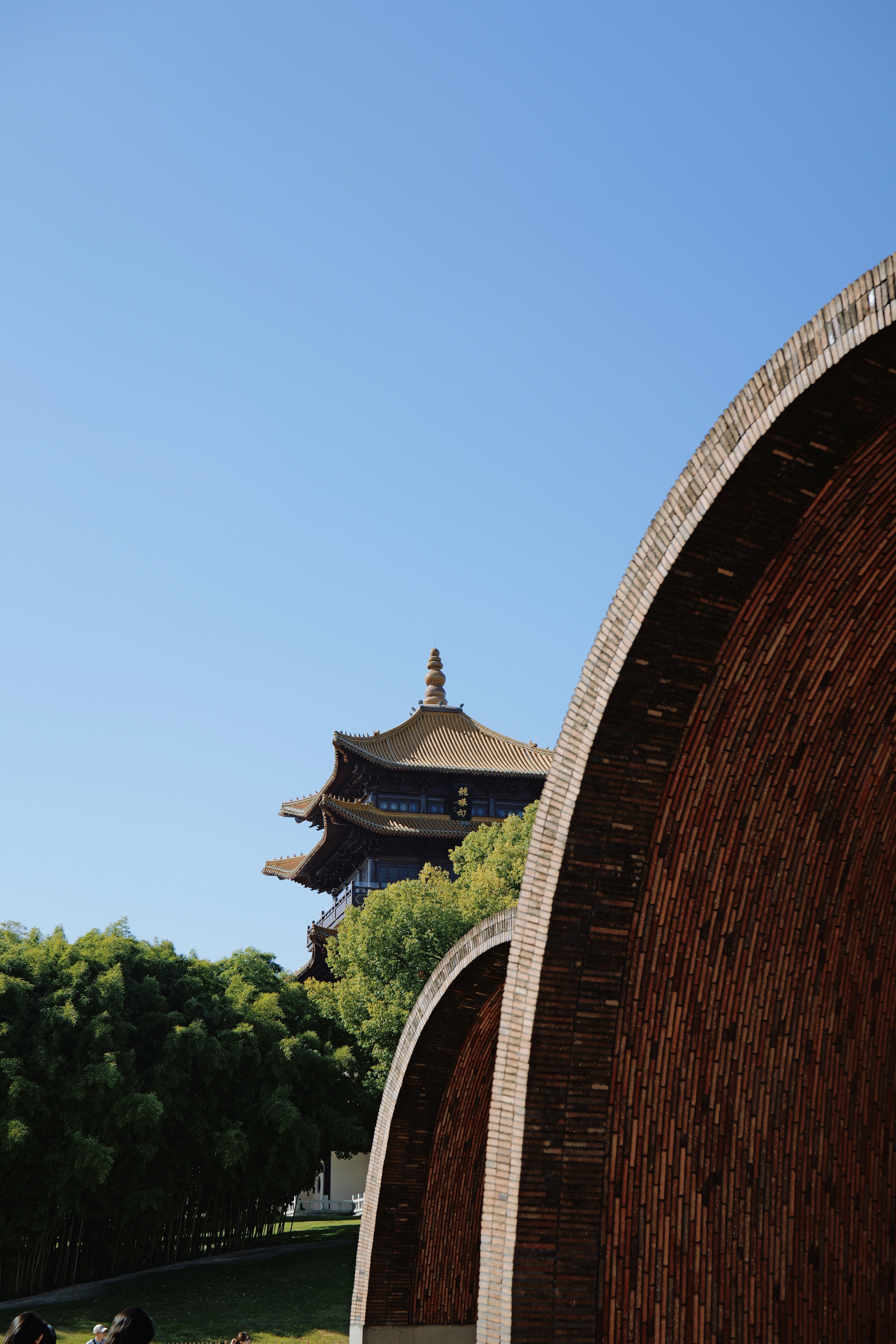 Curving brick structure with pagoda and trees