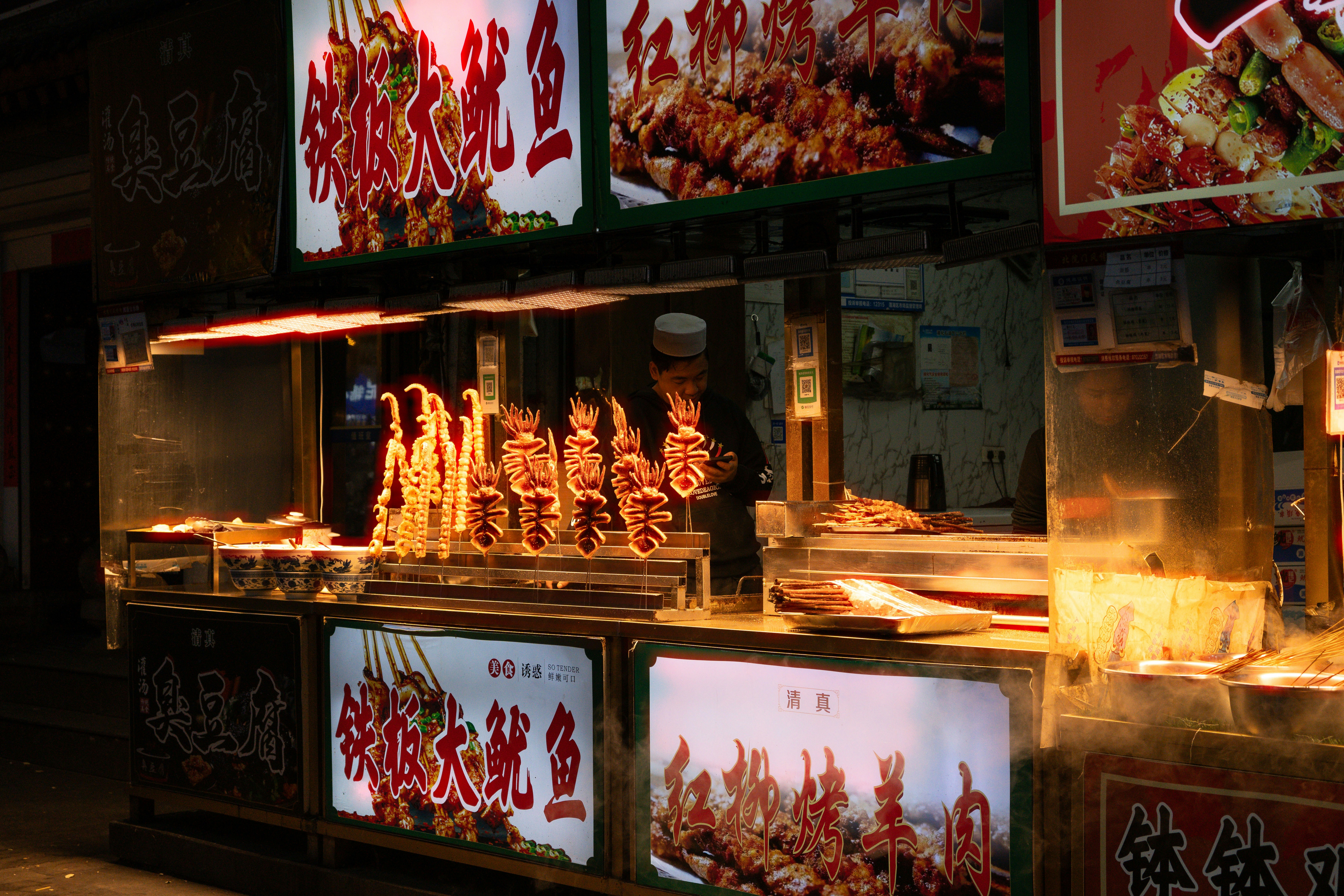 Street food stall with grilled skewers at night