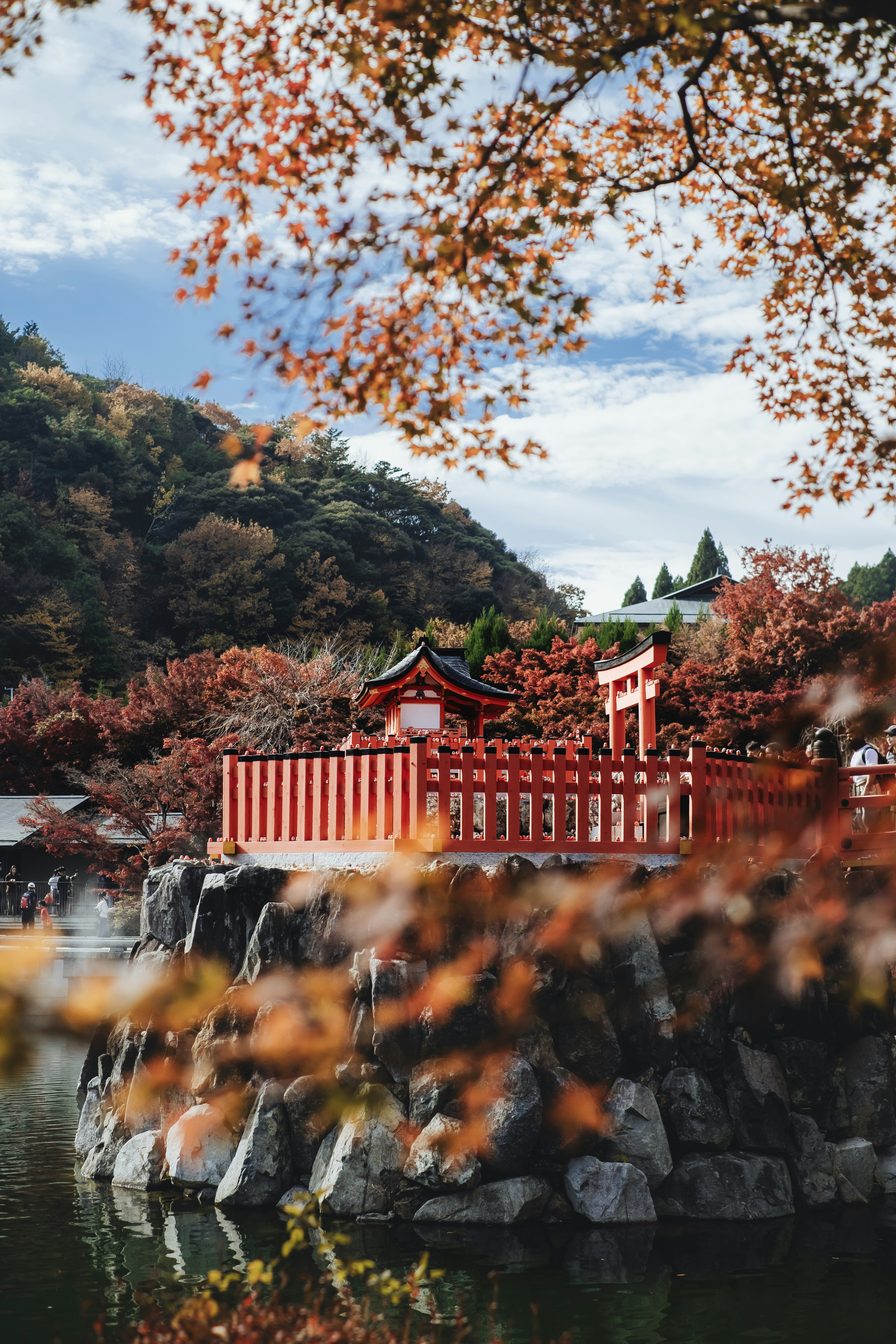 Japanese temple with vibrant autumn foliage and lake