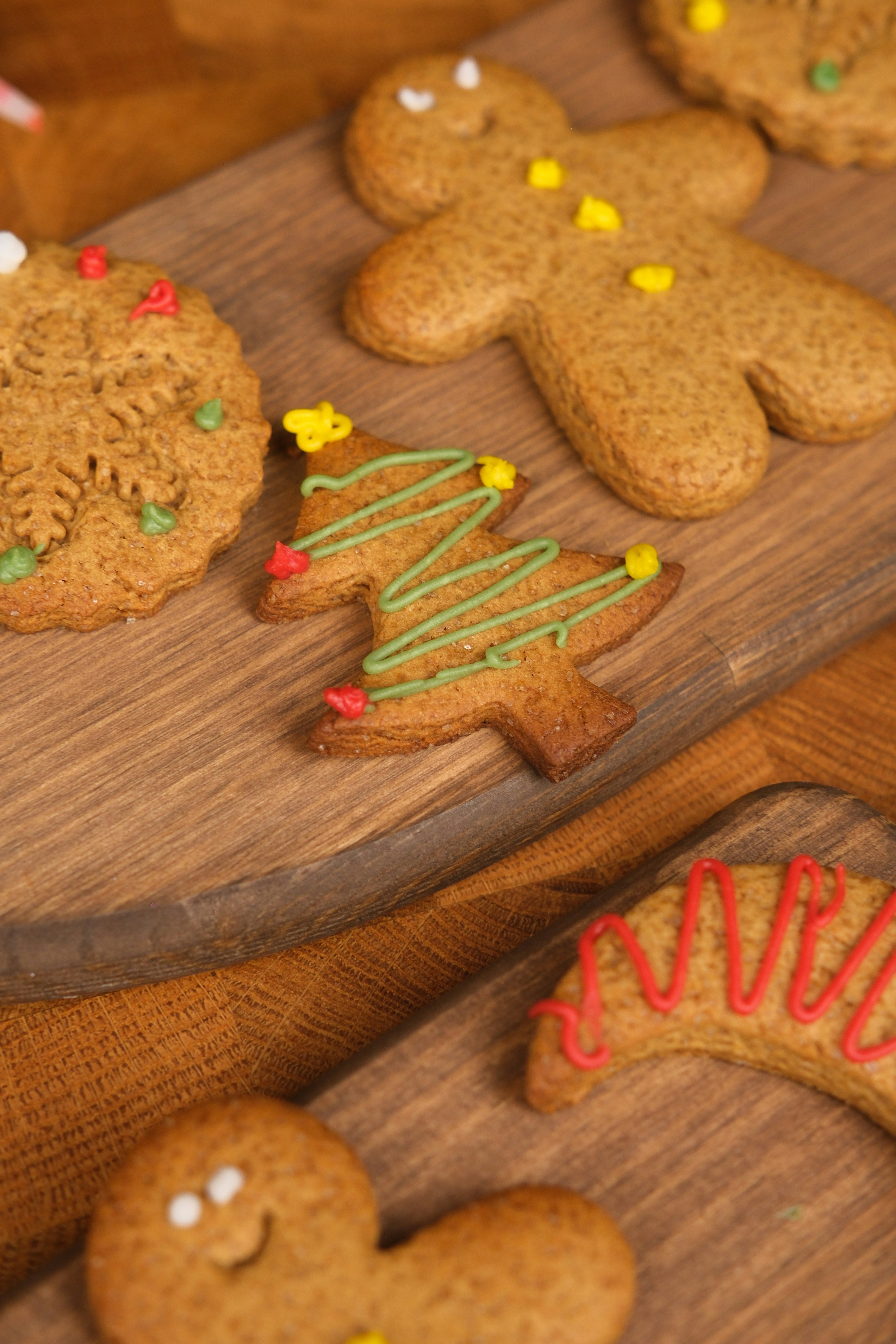 Decorated gingerbread cookies on a wooden surface.