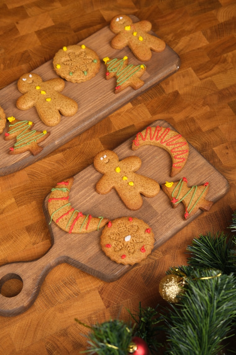 Christmas gingerbread cookies on wooden boards with festive lights — photo by Cemrecan Yurtman on Unsplash