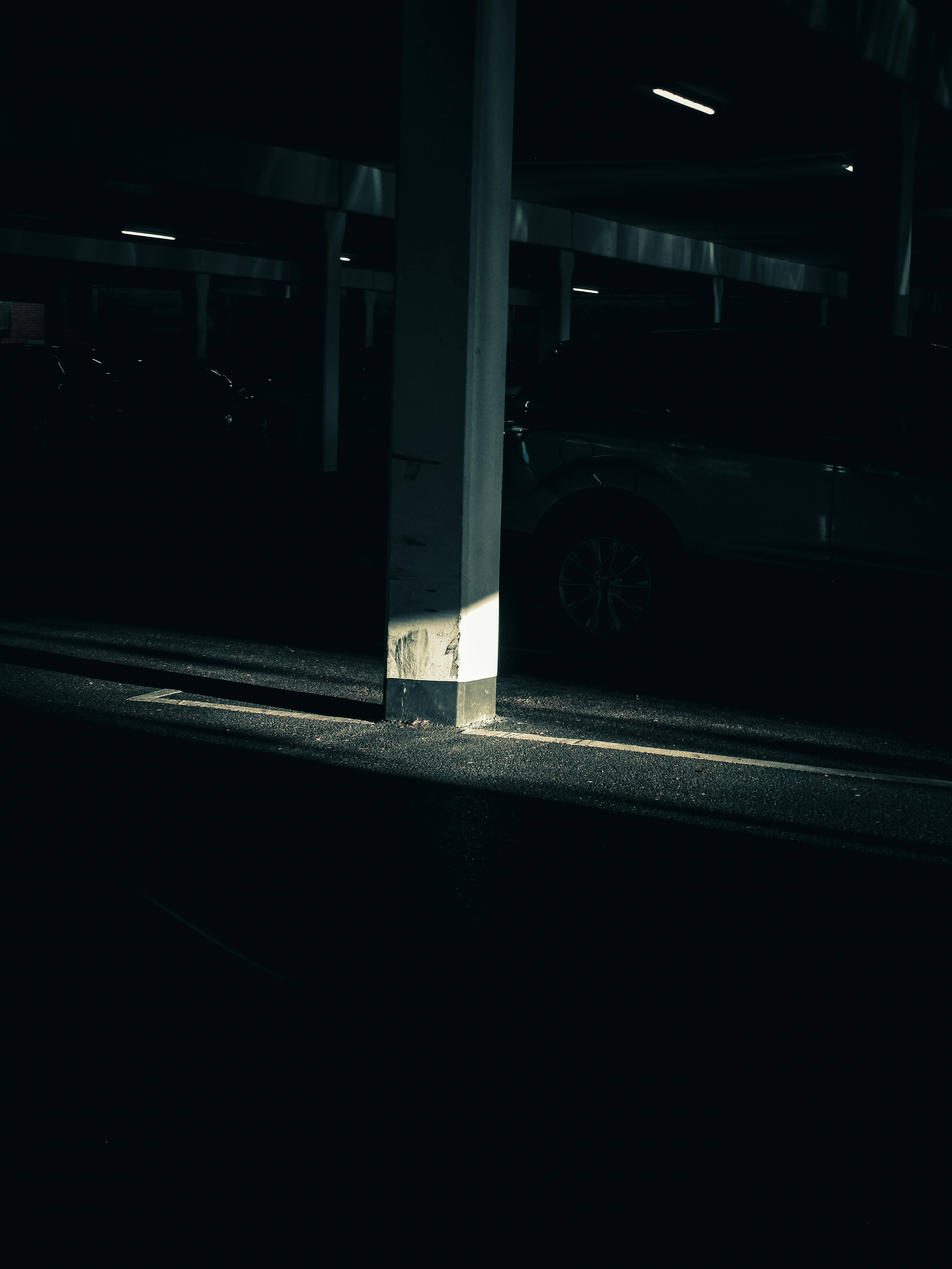 A concrete pillar casts a shadow at night.
