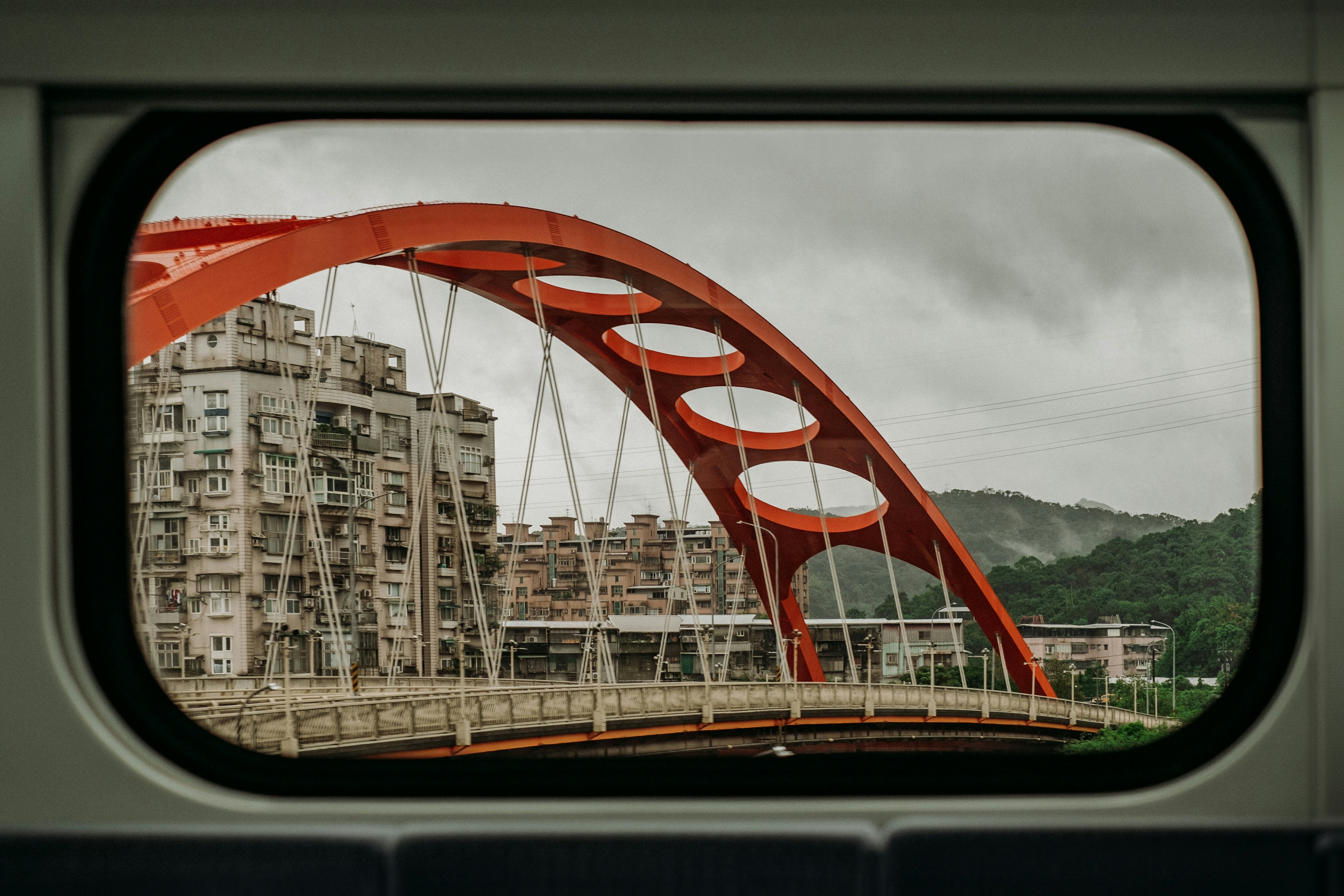 Red arched bridge seen through train window