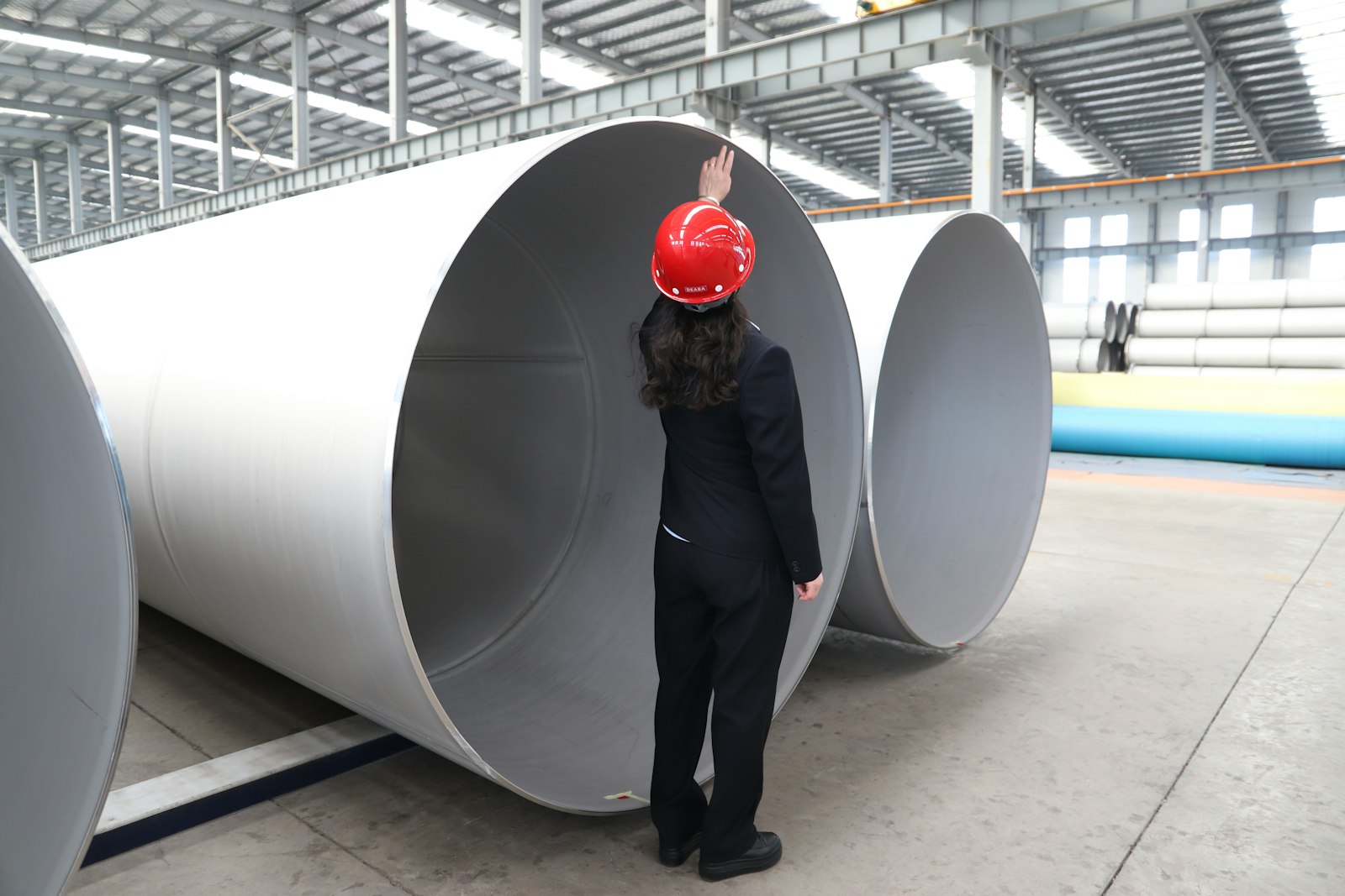 Supervisor inspecting steel pipe on the plant floor, a core part of frontline supervisor training